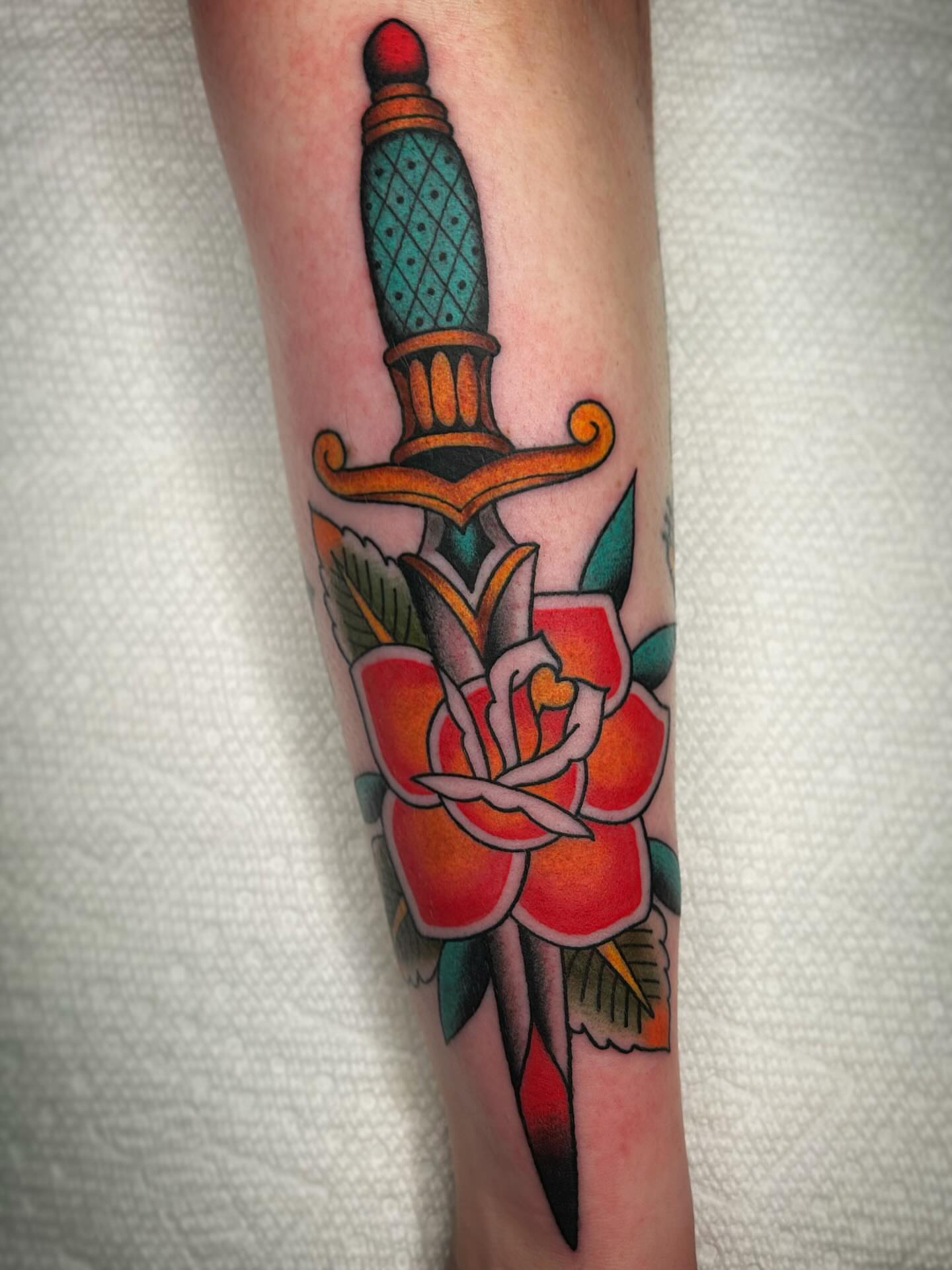 Knife and rose American traditional tattoo on the forearm by Kayla Shoffner