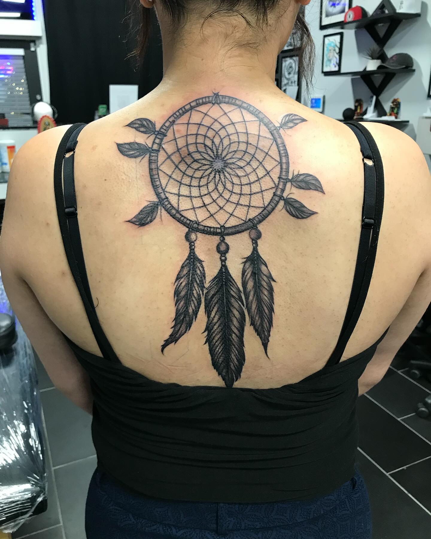 Dreamcatcher black and grey tattoo on the back by Chino's Tattoos