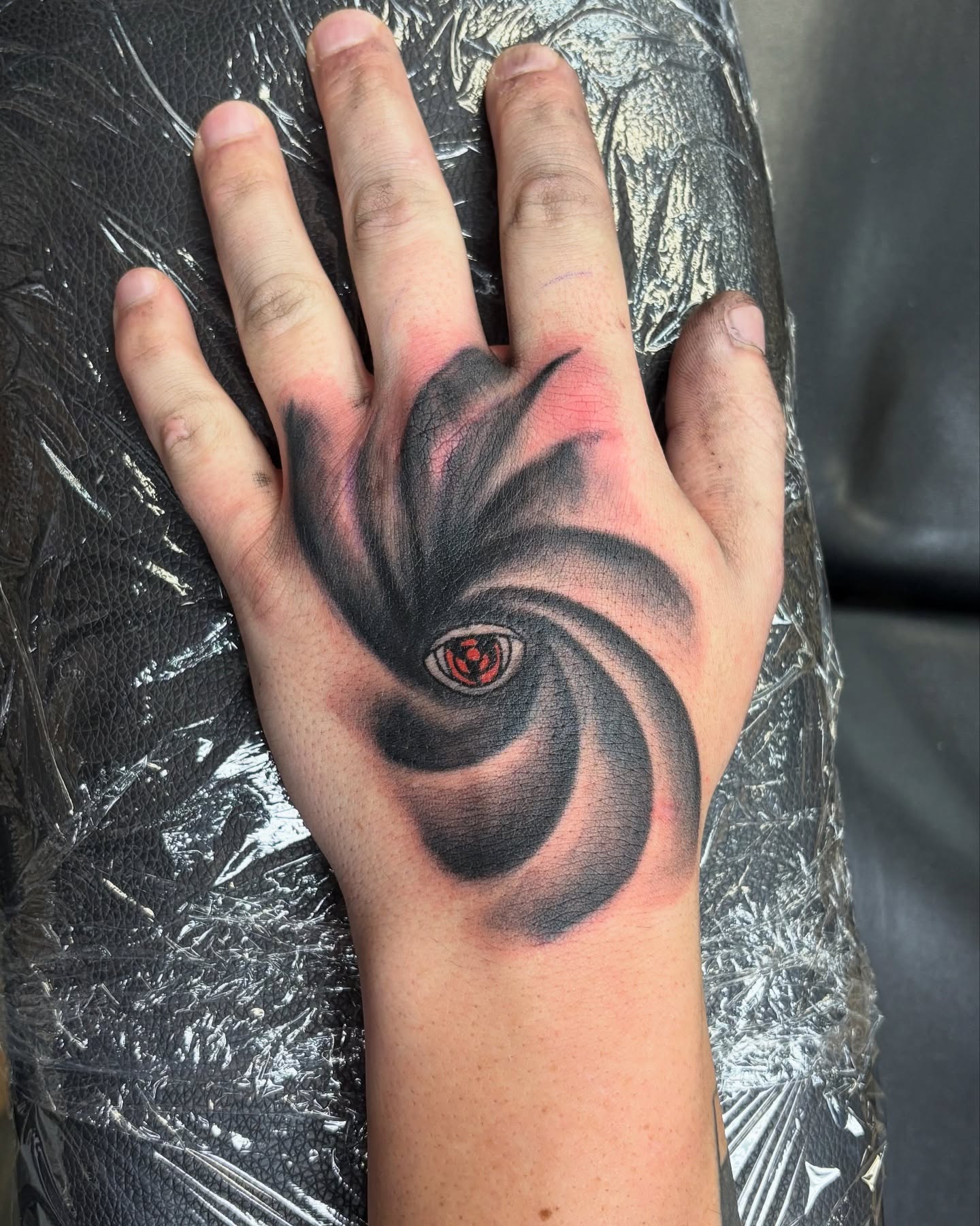 Eye in swirling vortex dark realism tattoo on the hand by Tori Anderson, Minneapolis, Minnesota