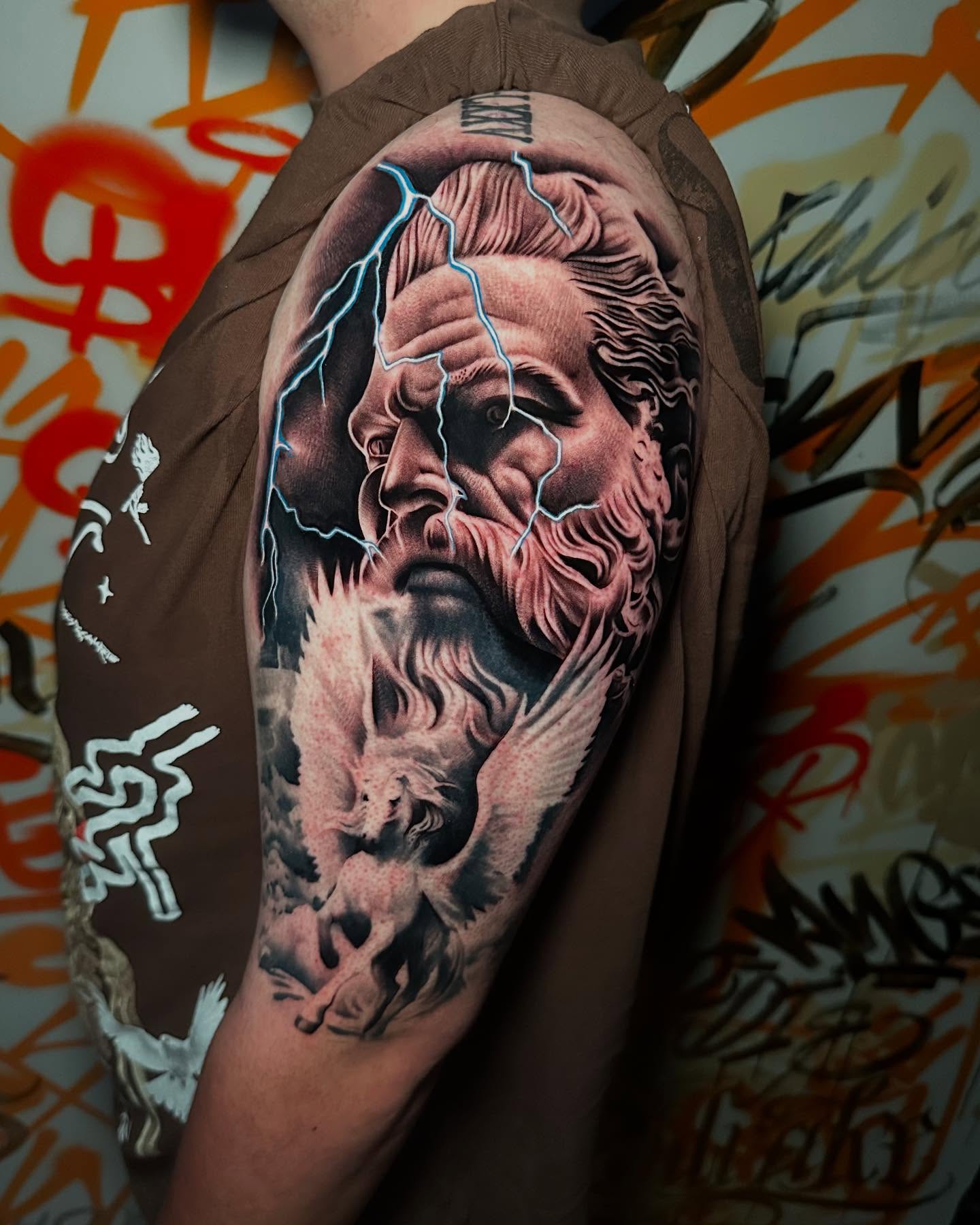 God-like figure with angel realism tattoo on the forearm by Miguel Saucedo
