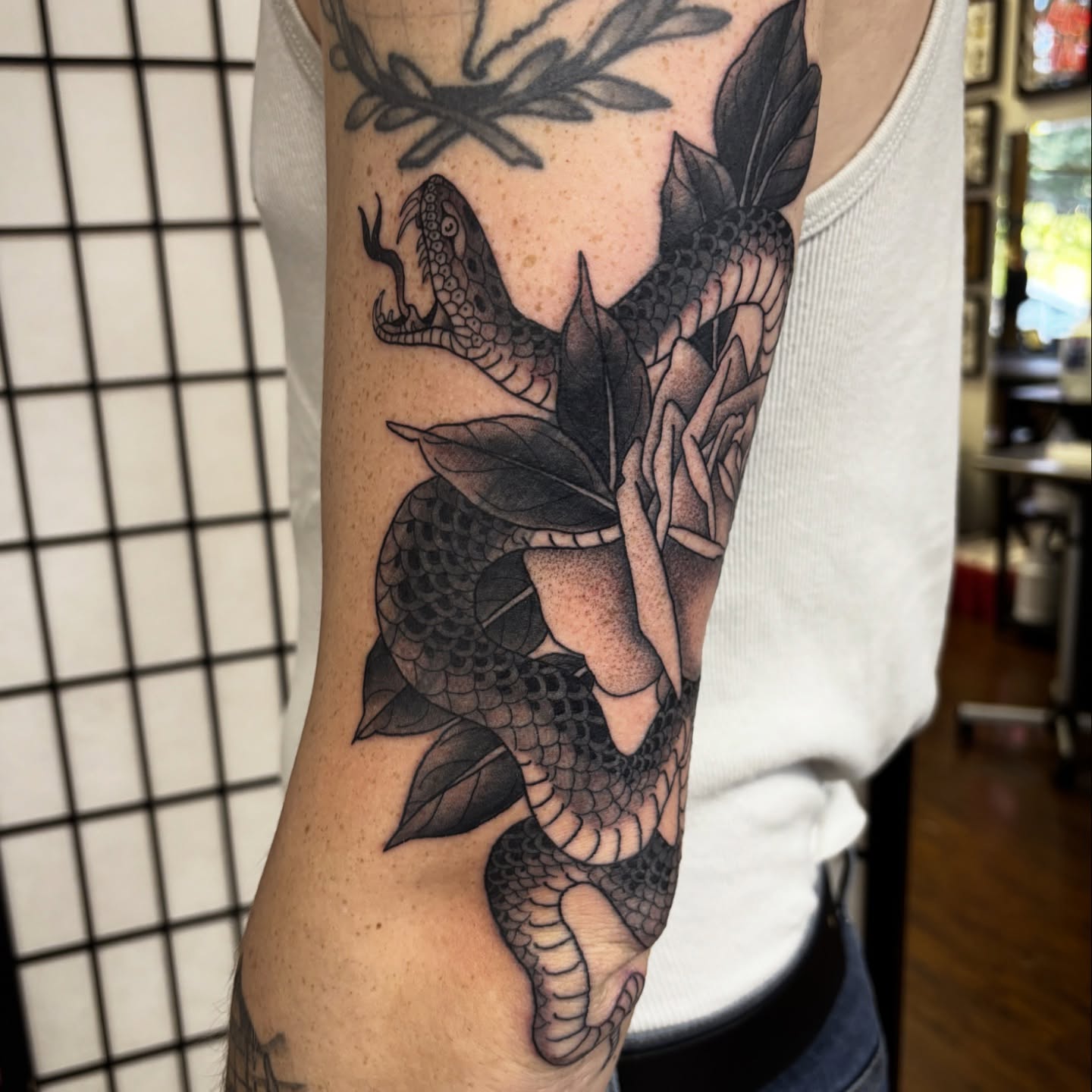 Snake and peony black and grey tattoo on the forearm by Adam Bailey, Portland, Oregon