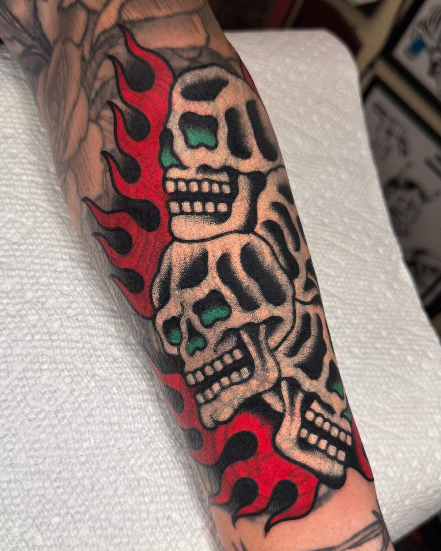 Skulls and flames American traditional tattoo on the forearm by James Shepherd, Austin, Texas