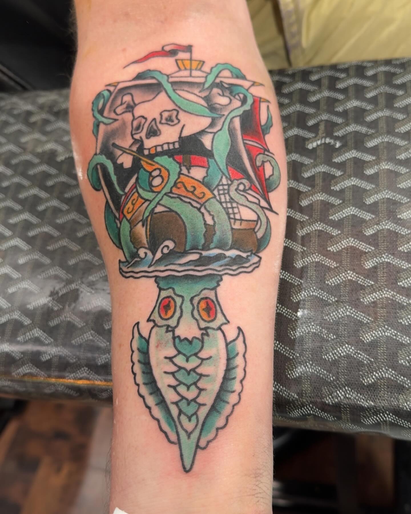 Pirate skull and ship American traditional tattoo on the forearm by Robbie Roberson
