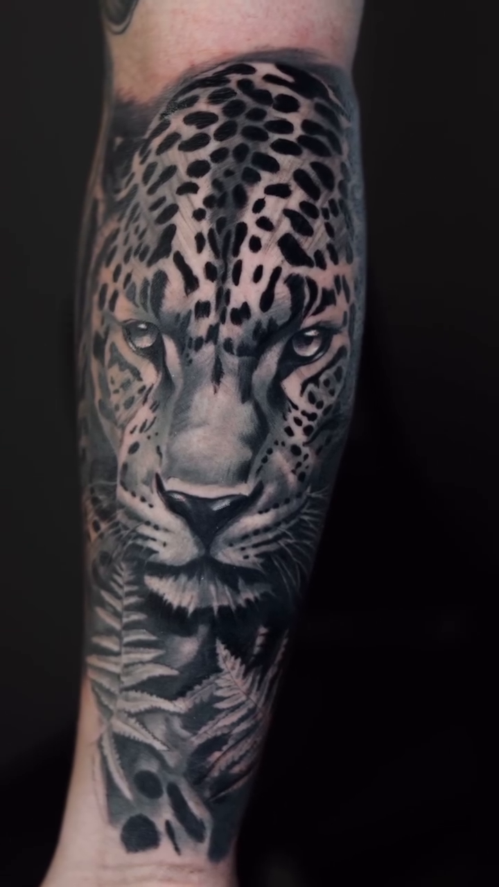 Leopard portrait with foliage realism tattoo by Luis Arenas