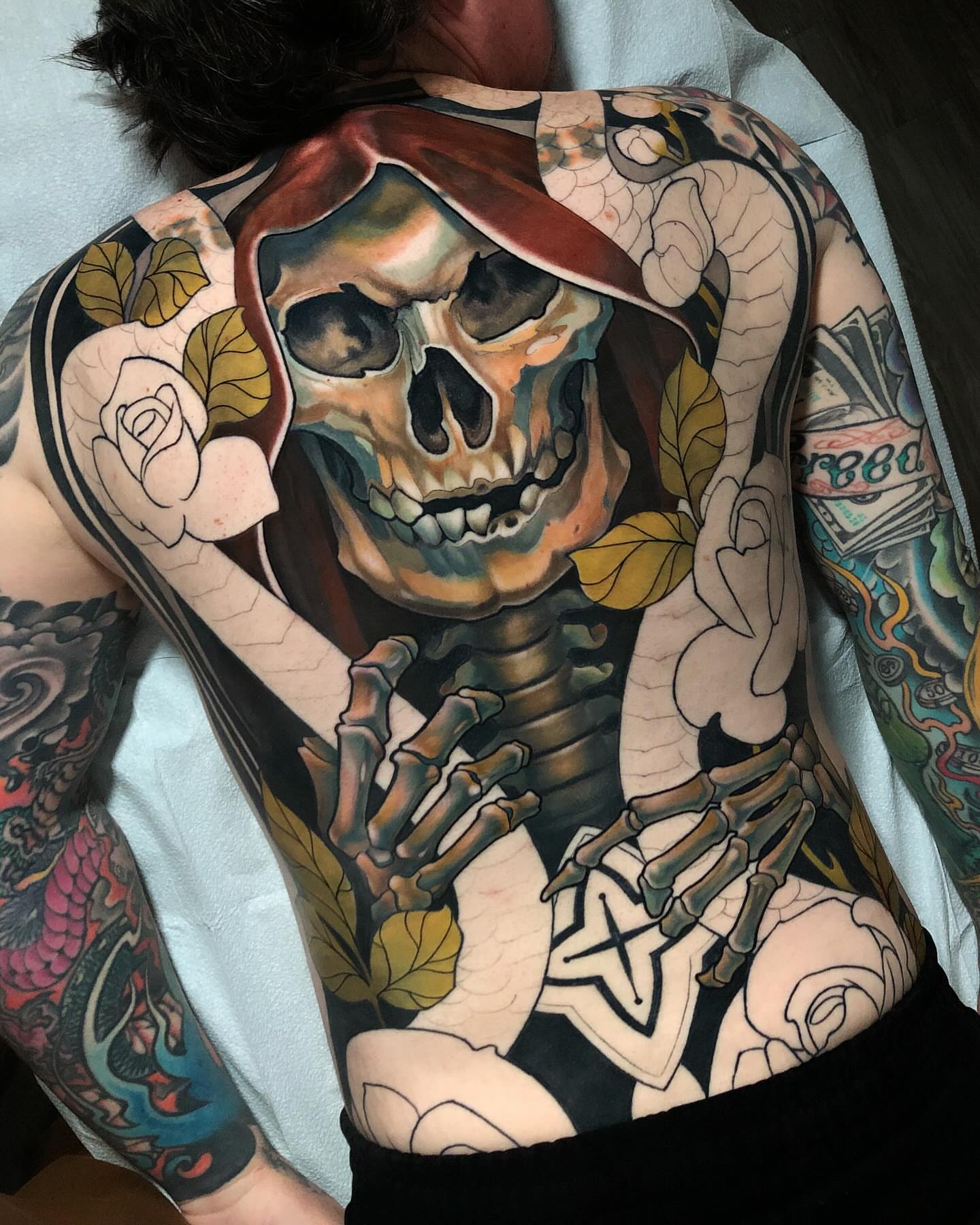 Skeleton with rose American traditional tattoo on the back by Milo Alfring Tattoo