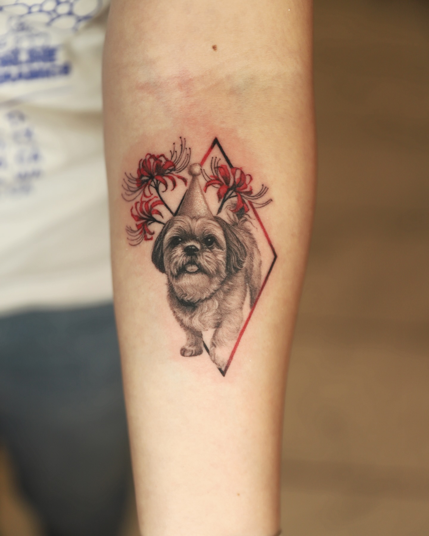 Dog wearing party hat geometric tattoo on the forearm by Las Vegas tattoo