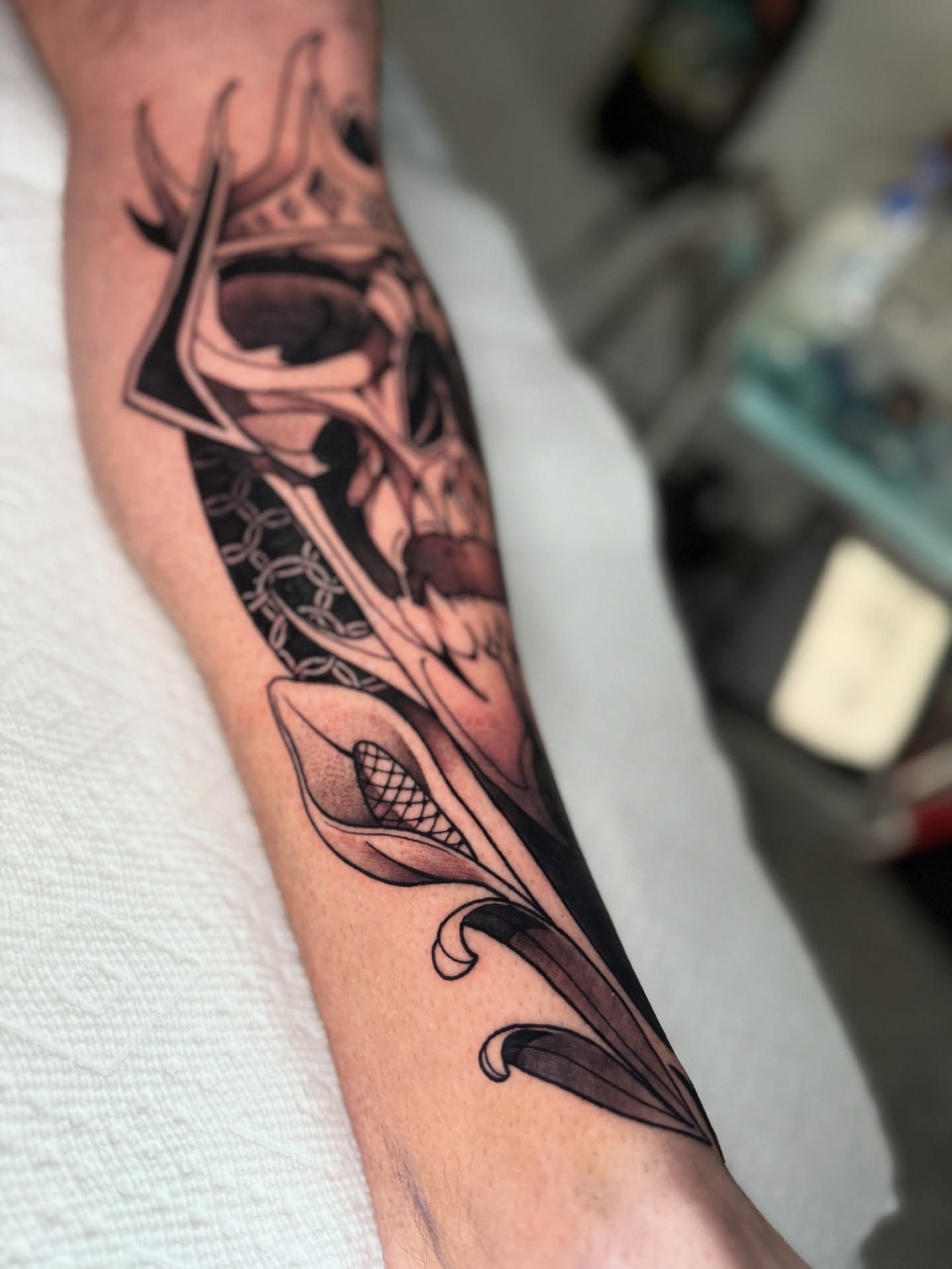 Skull and calla lily realism tattoo on the forearm by Neotrav Tattoos