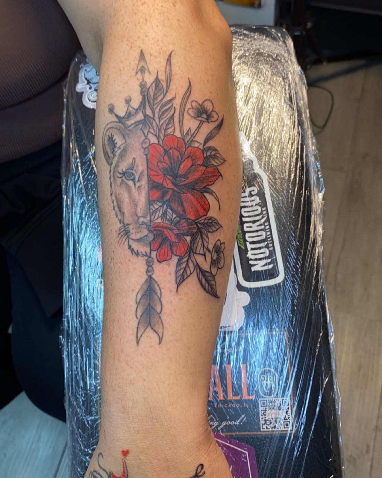 Lion and flowers American traditional tattoo on the forearm by Tattsruru