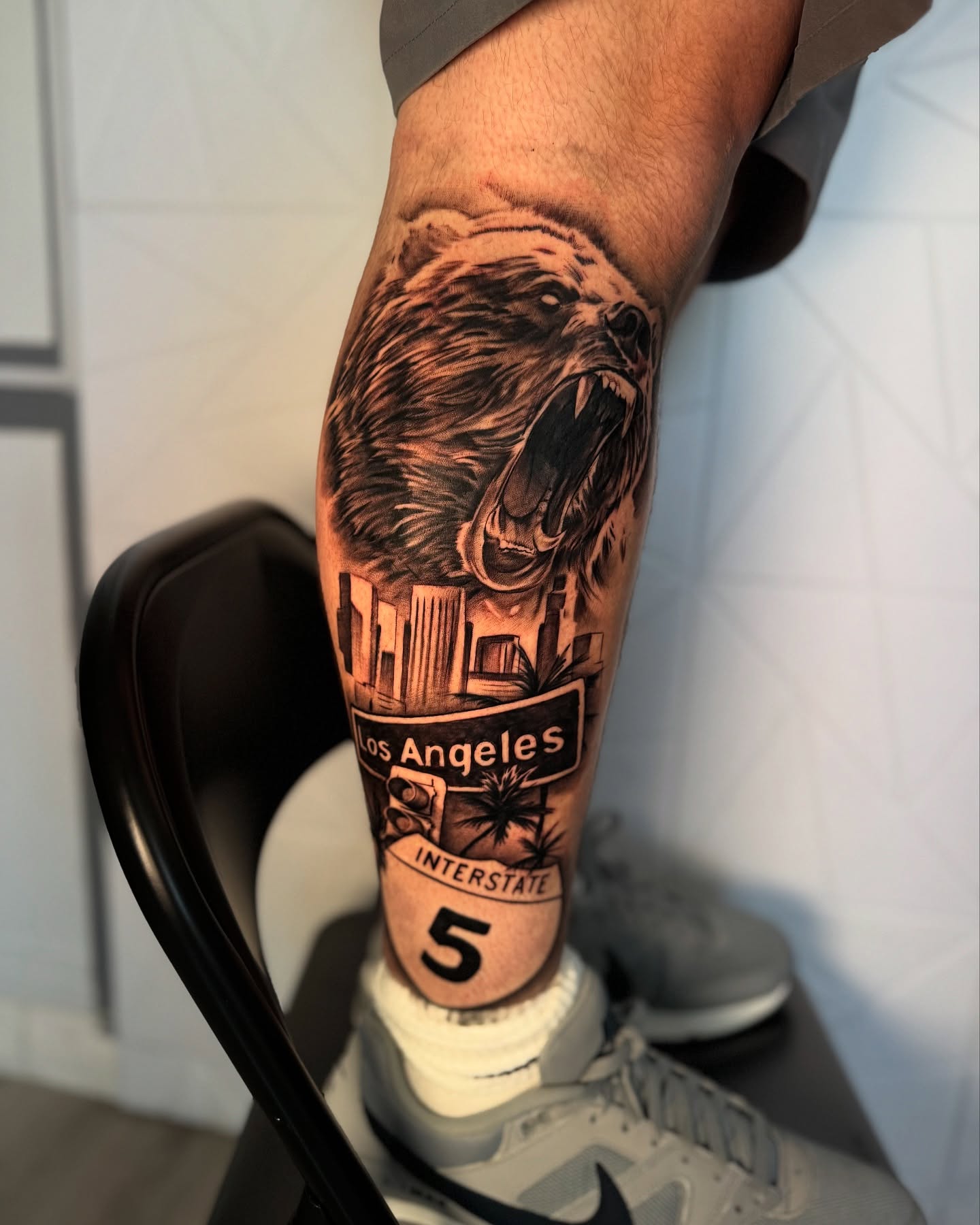 Bear and cityscape realism tattoo on the forearm by Isiah Hall, Whittier, California