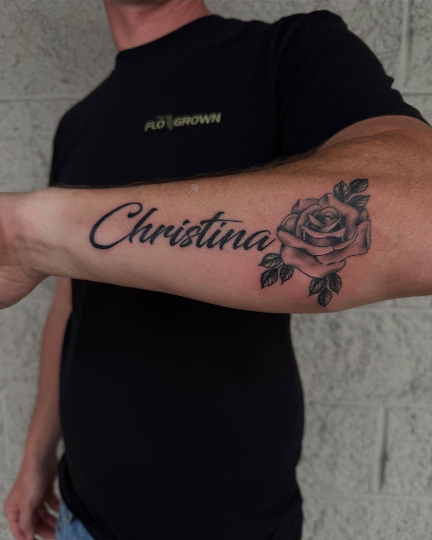 Name and rose black and grey tattoo on the forearm by Kylee langford 🧿