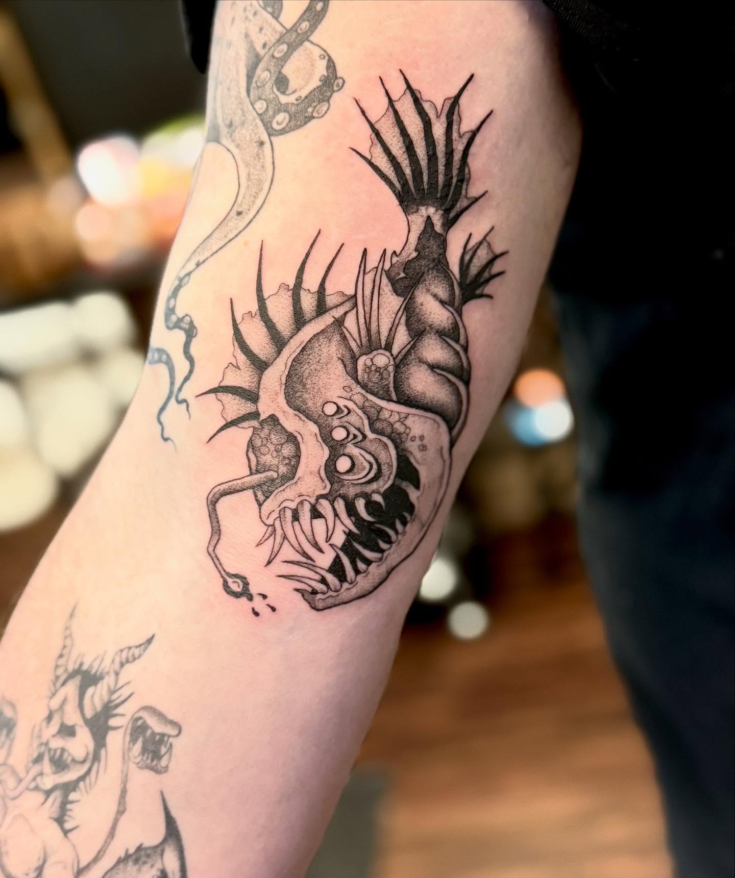 Heart with tentacles dark realism tattoo on the forearm by Katie Stacy