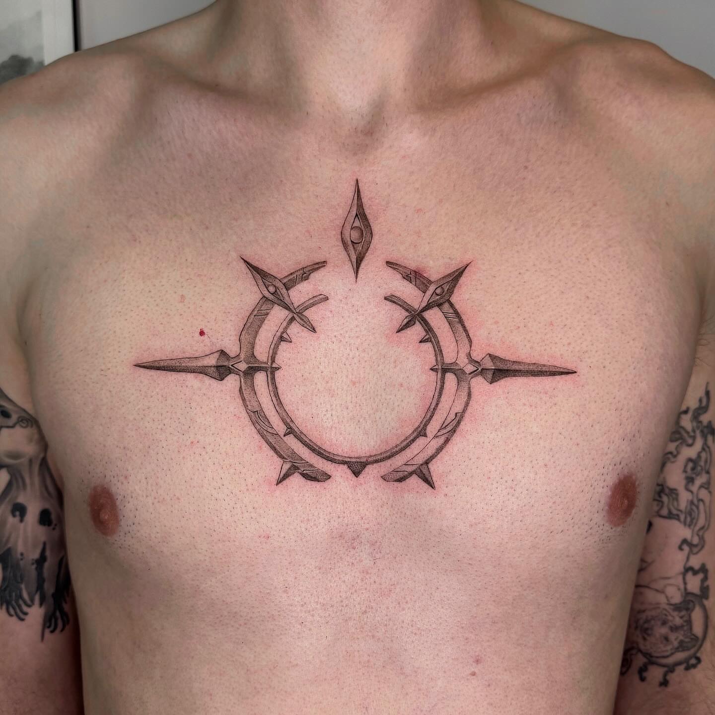 Circle with spikes geometric tattoo on the chest by Alyssa . Villela