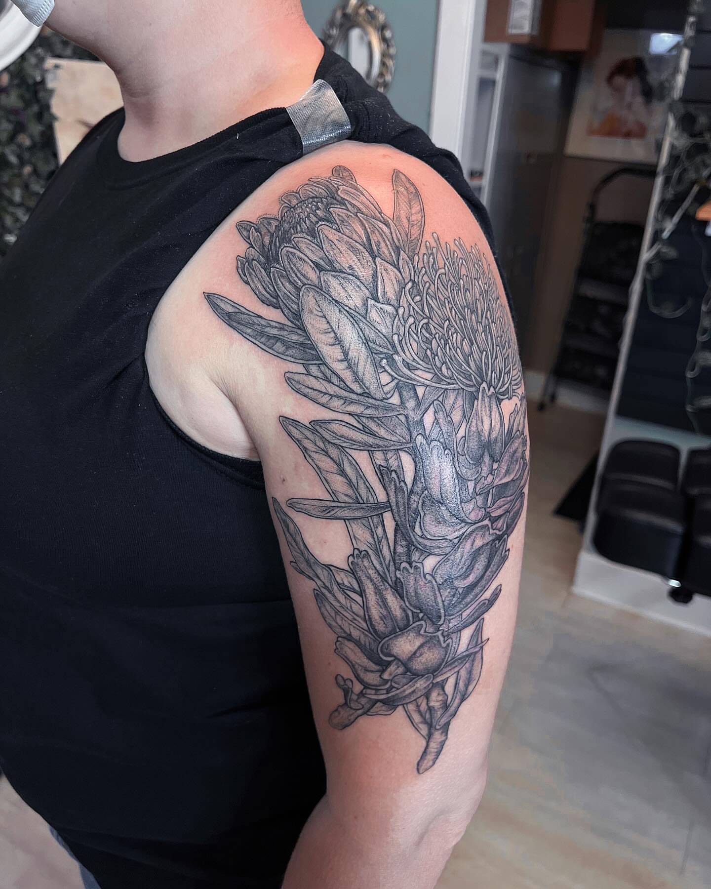 Protea flower black and grey tattoo on the shoulder by 𝗝𝗲𝘀𝘀𝗶𝗲 𝗩𝗶𝗼𝗹𝗲𝘁