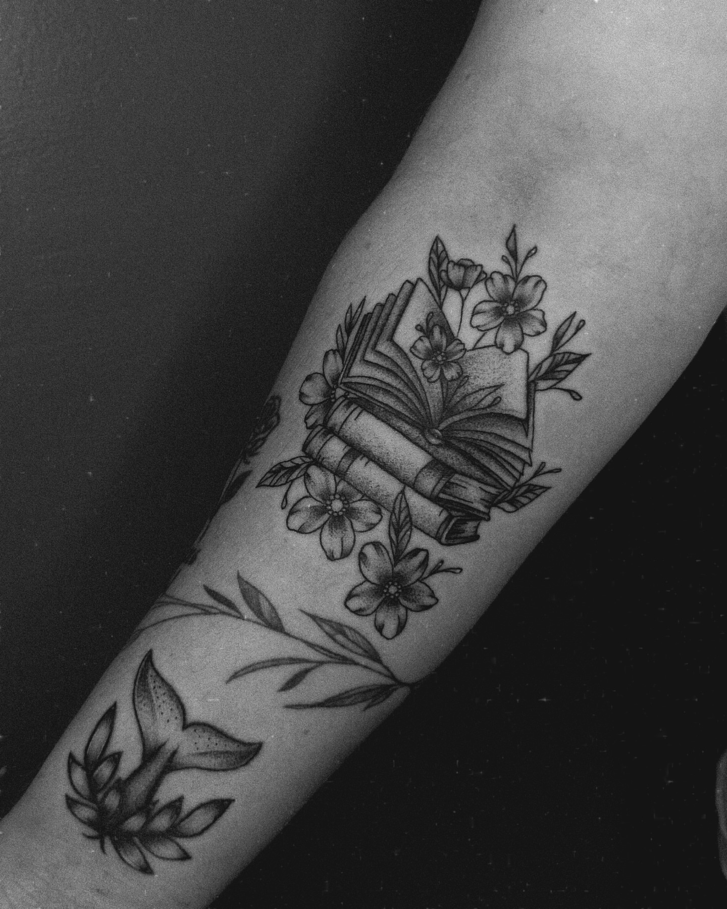 Book and flowers black and grey tattoo on the forearm by E L I Z A H B e T H H D e S I G N S