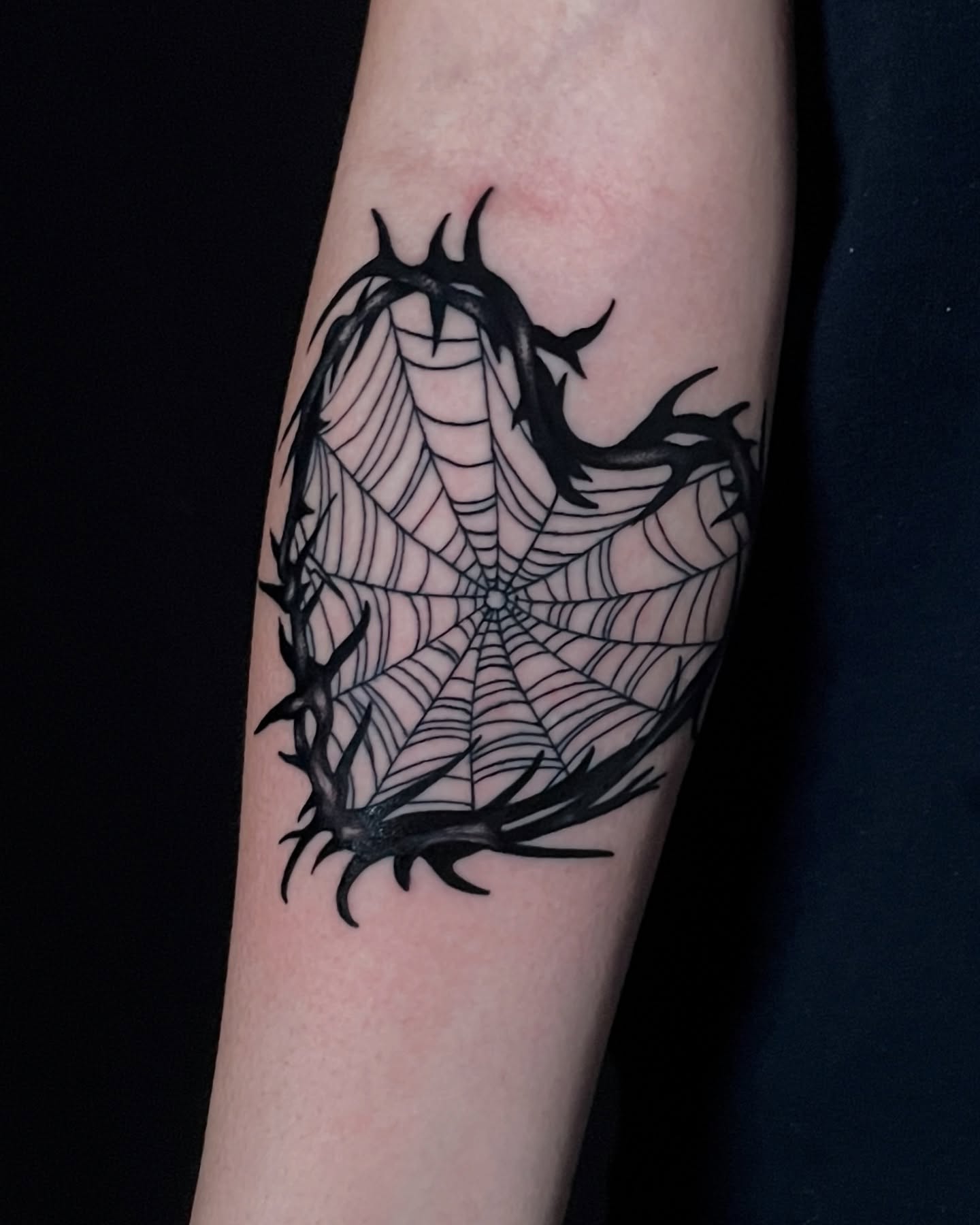 Spider web black and grey tattoo on the forearm by Austin Clark