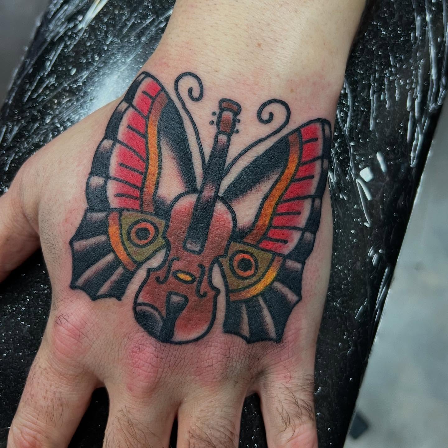 Butterfly violin American traditional tattoo on the hand by doodle