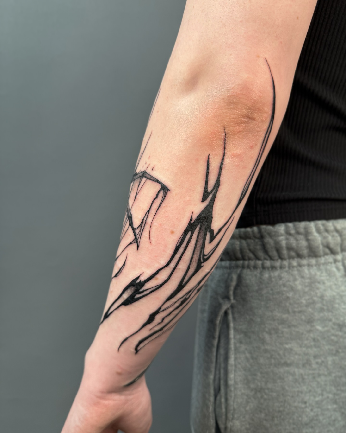 Abstract flame black and grey tattoo on the forearm by Tattoo Artist