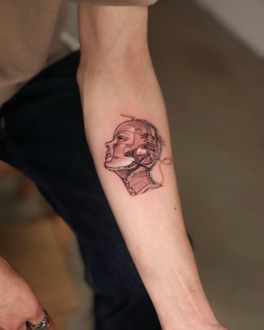 Astronaut helmet realism tattoo on the forearm by Joy Christiana