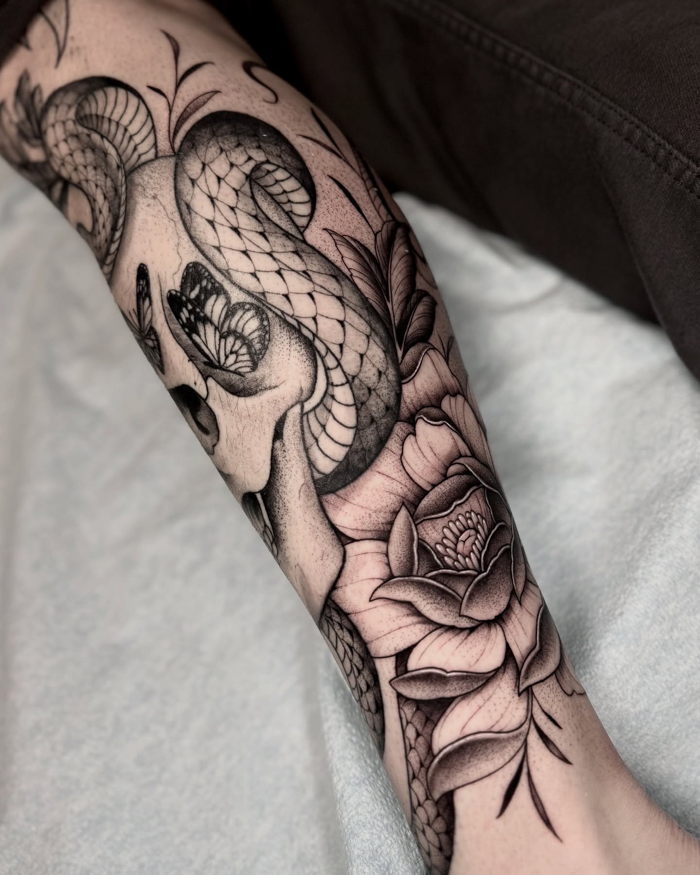 Snake and peony realism tattoo on the forearm by Kathryn Semus