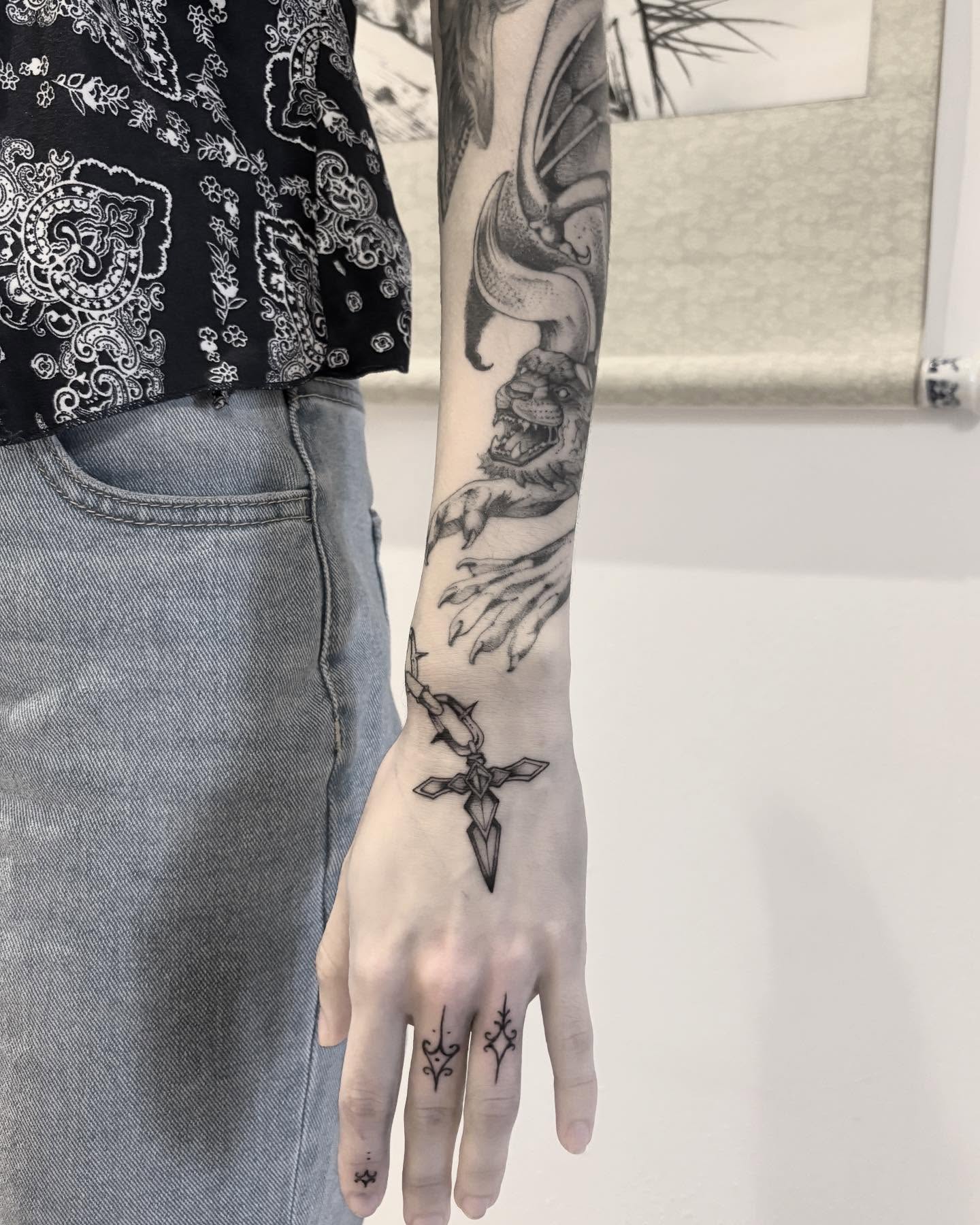Cross and dragon black and grey tattoo on the forearm by Becci Chelicerata