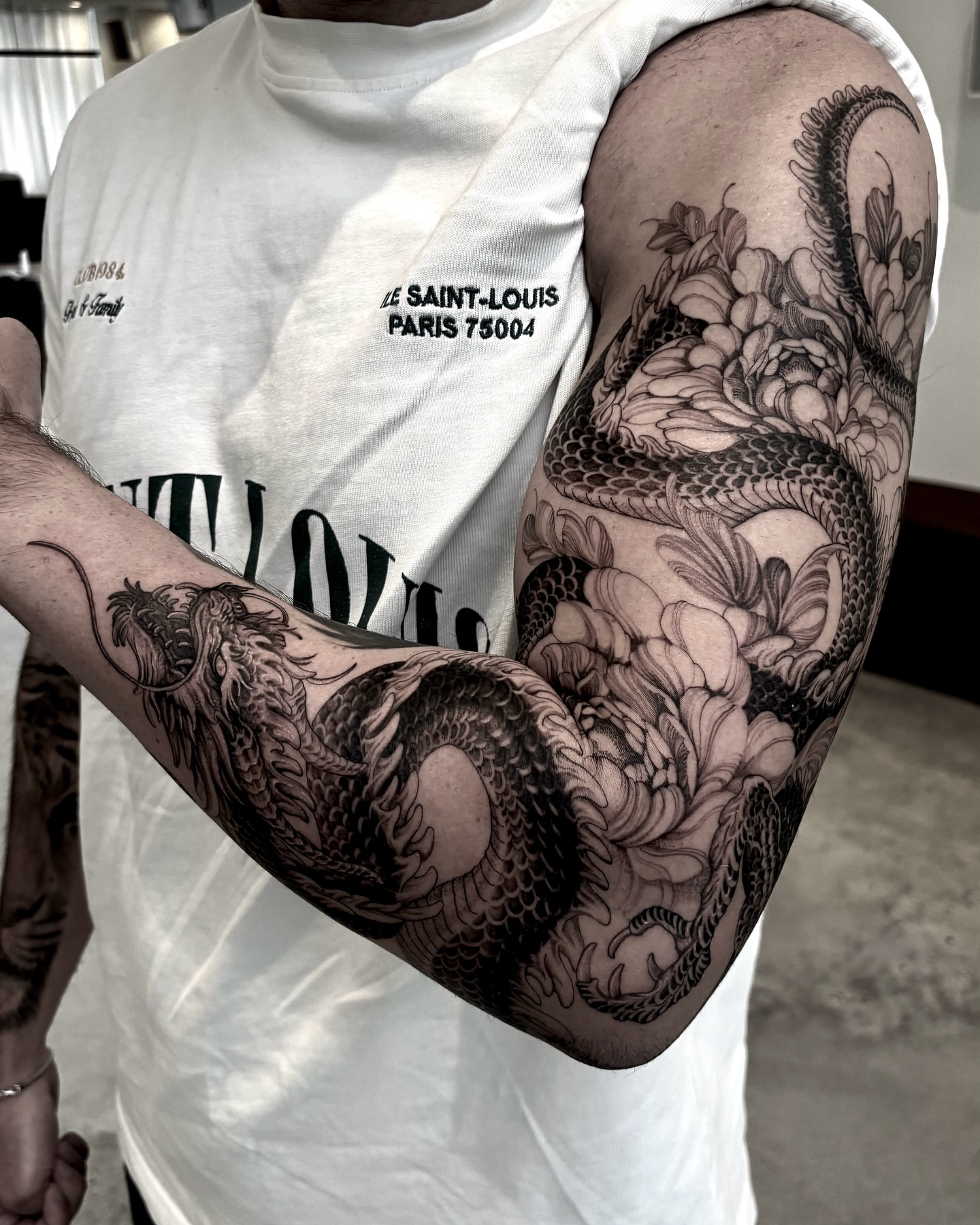 Dragon and flowers realism tattoo on the forearm by Yongjun