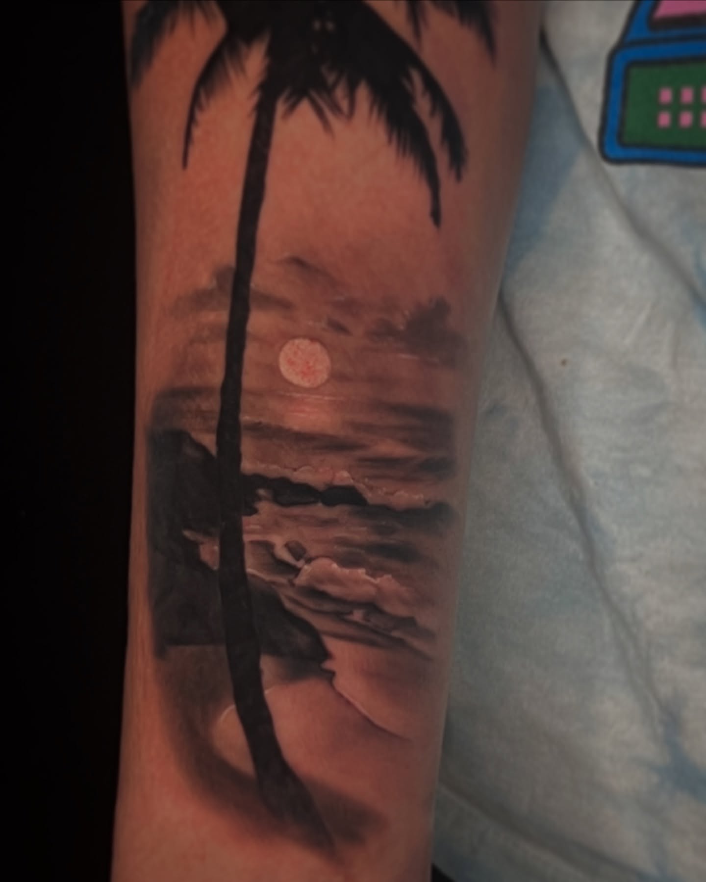 Palm tree sunset realism tattoo on the forearm by Jordan