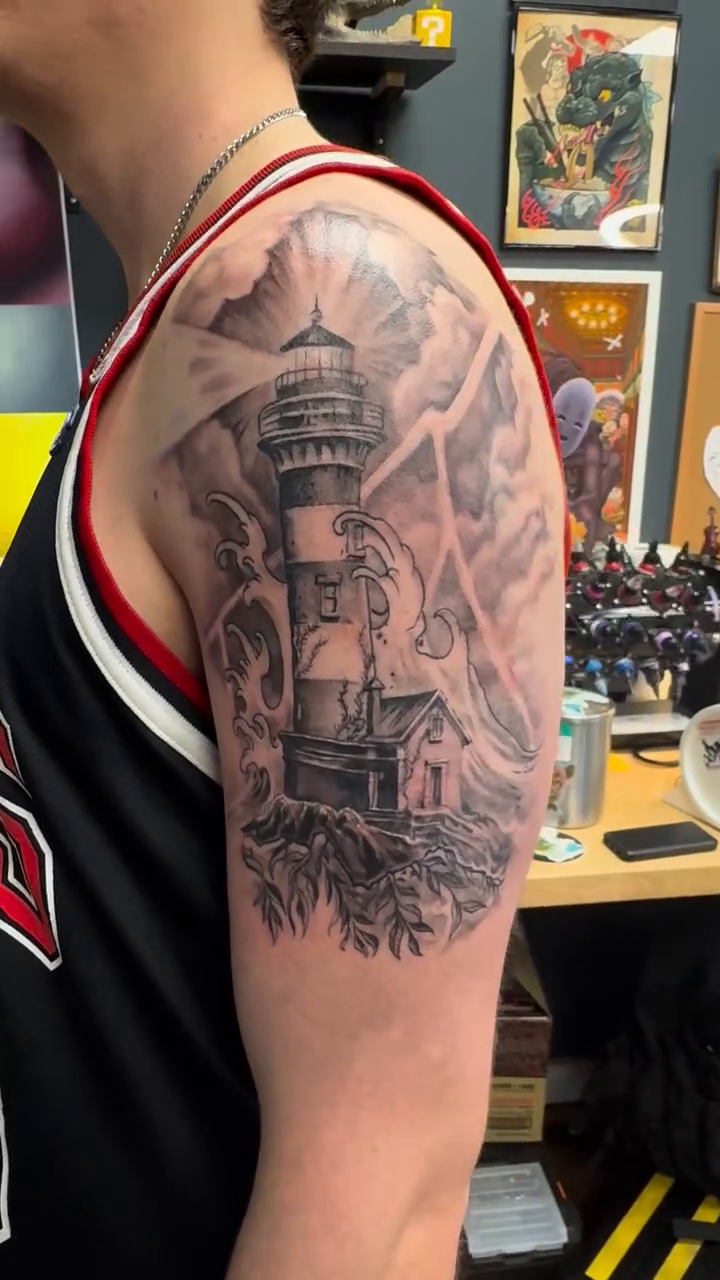 Lighthouse with stormy sea and sky realism tattoo by Hori Shit