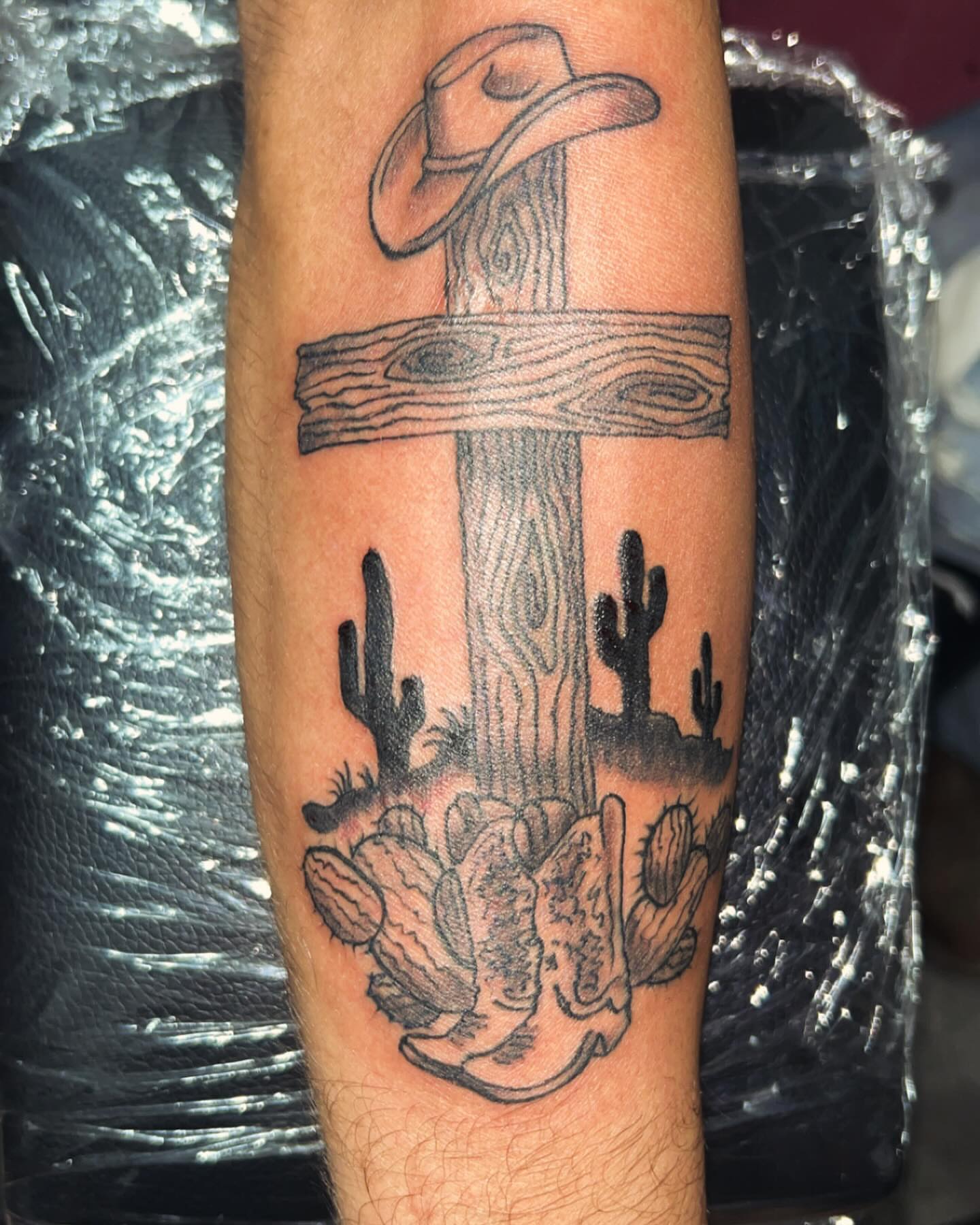 Cowboy hat and cactus black and grey tattoo on the forearm by Anna DeLuna