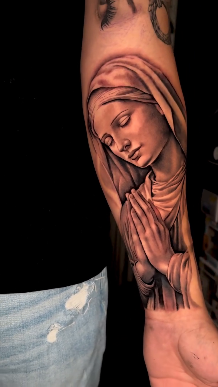Virgin Mary praying Chicano tattoo on the forearm by Kaleb Trujillo