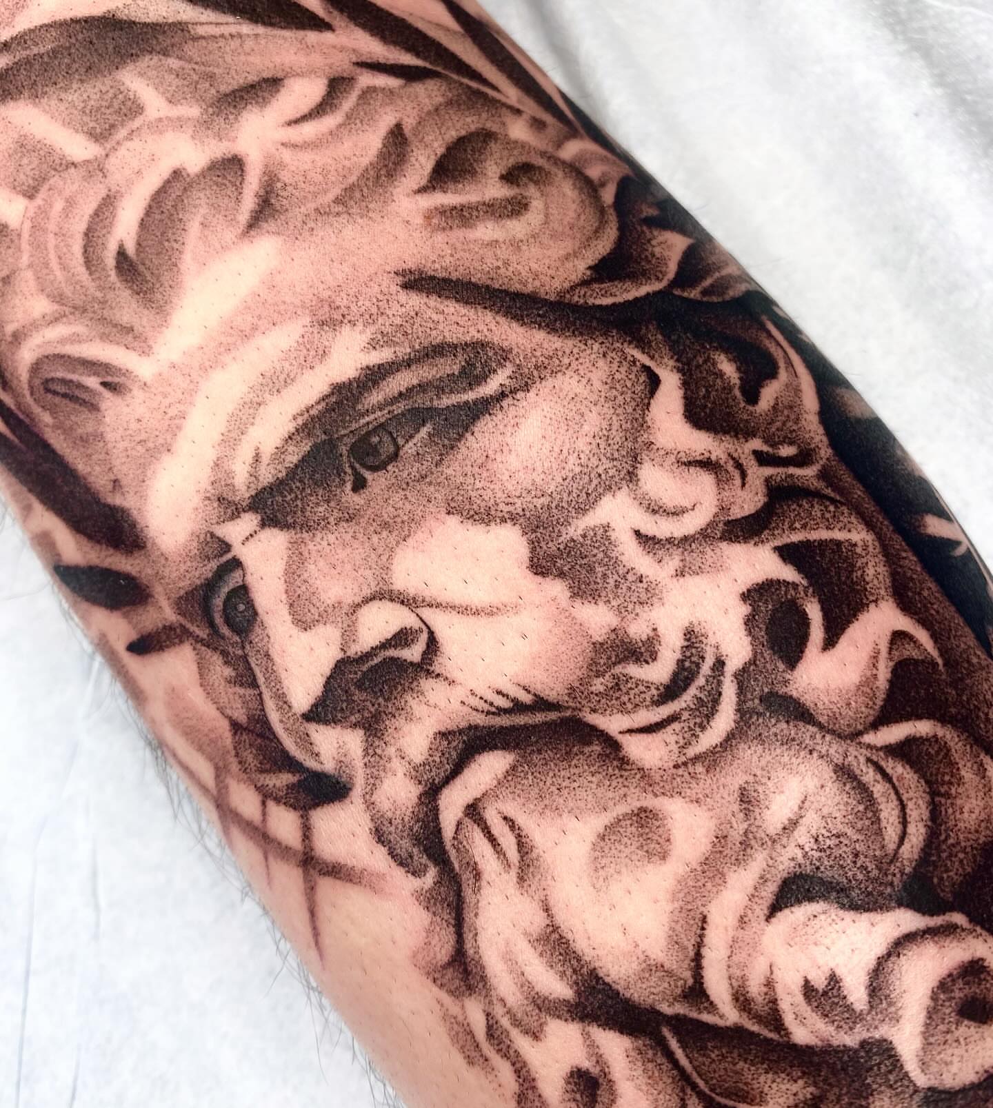 Flame and face dotwork tattoo on the forearm by Cody Mason