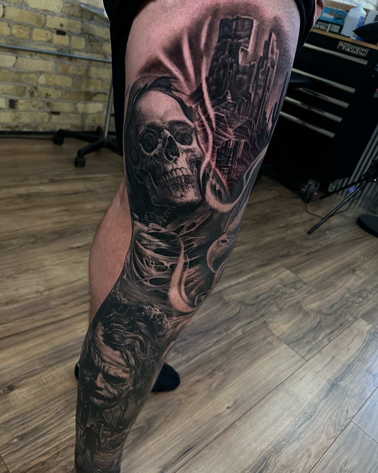 Skull and cityscape realism tattoo on the leg by Aaron, Milwaukee, Wisconsin