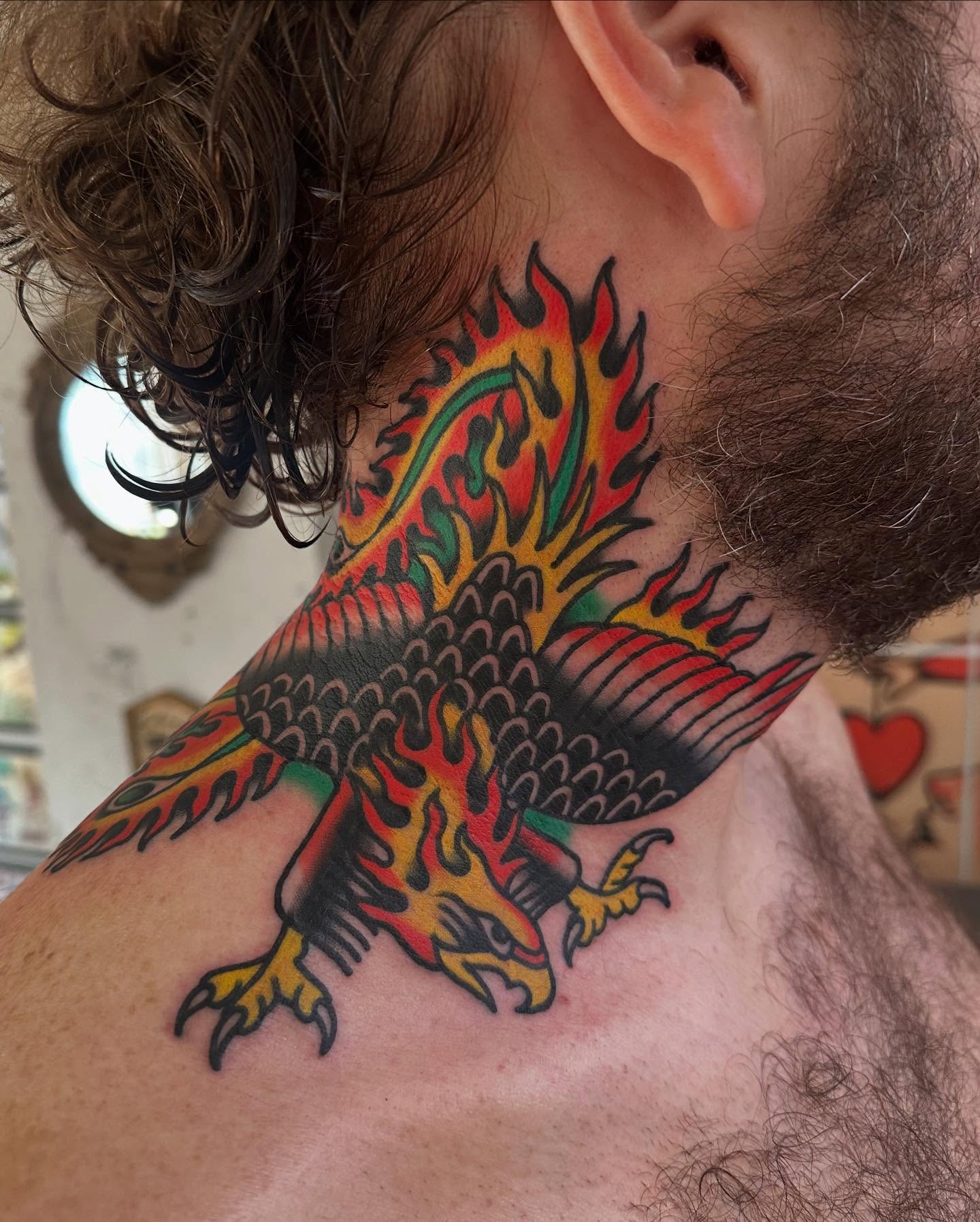 Flaming phoenix American traditional tattoo on the neck by Steve Pearson