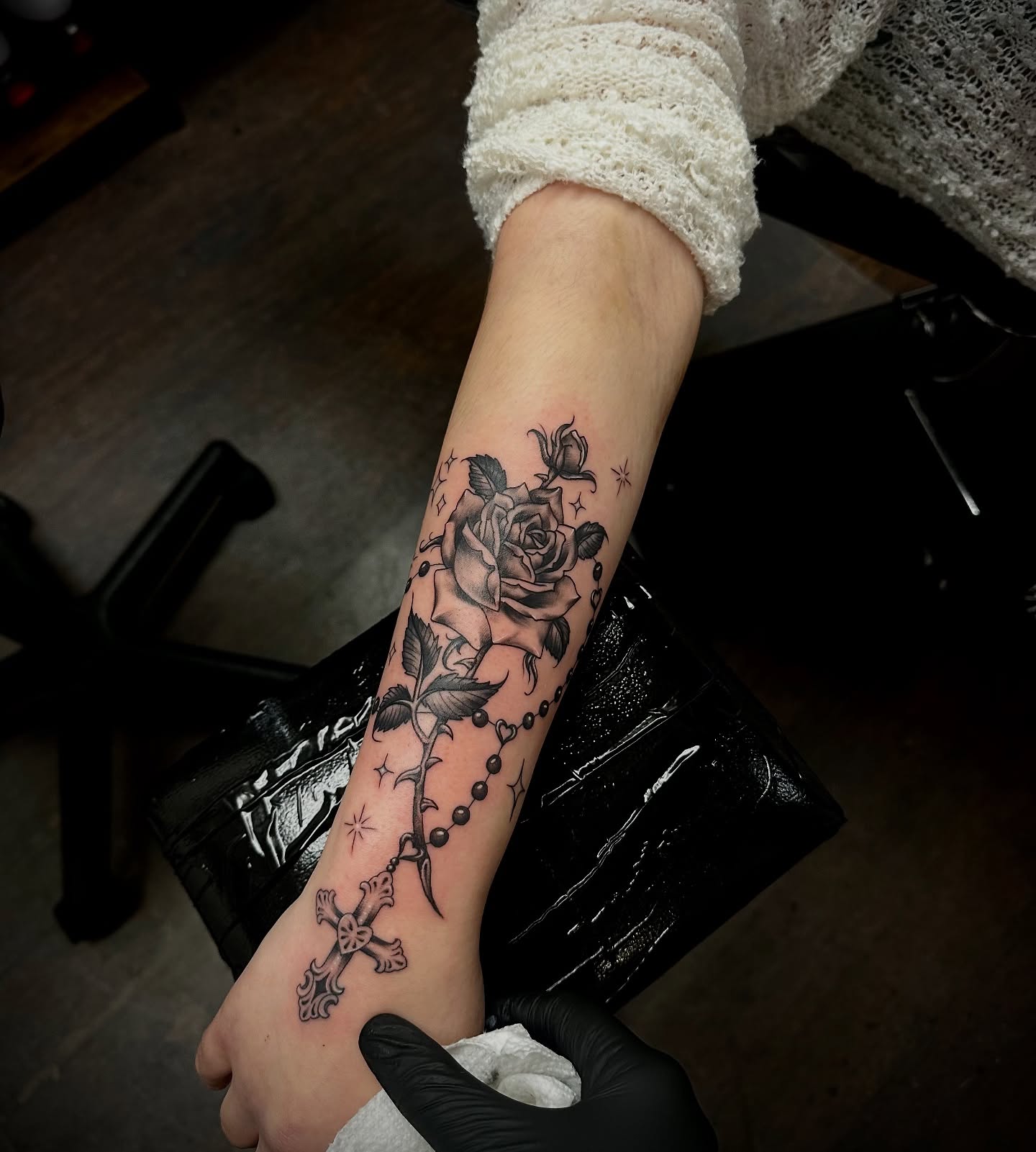 Roses and cross black and grey tattoo on the forearm by Kassie Perian