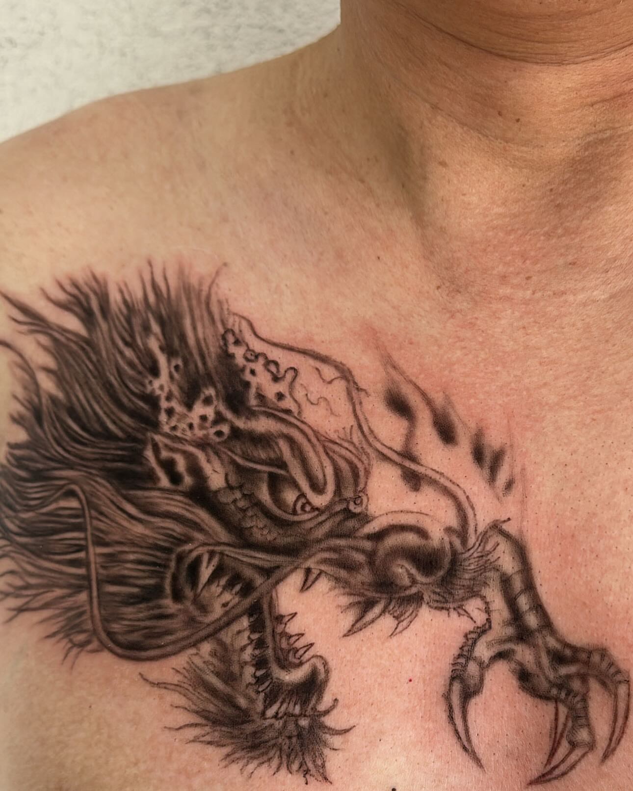 Dragon black and grey tattoo on the chest by Healoha “Lindelle” Kamanu