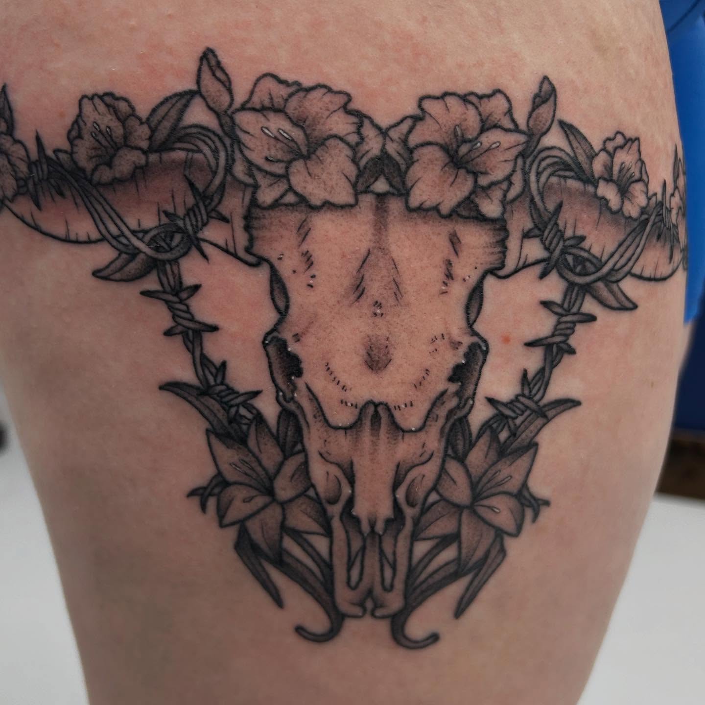 Skull and flowers black and grey tattoo on the thigh by Abby Watts, Columbus, Ohio