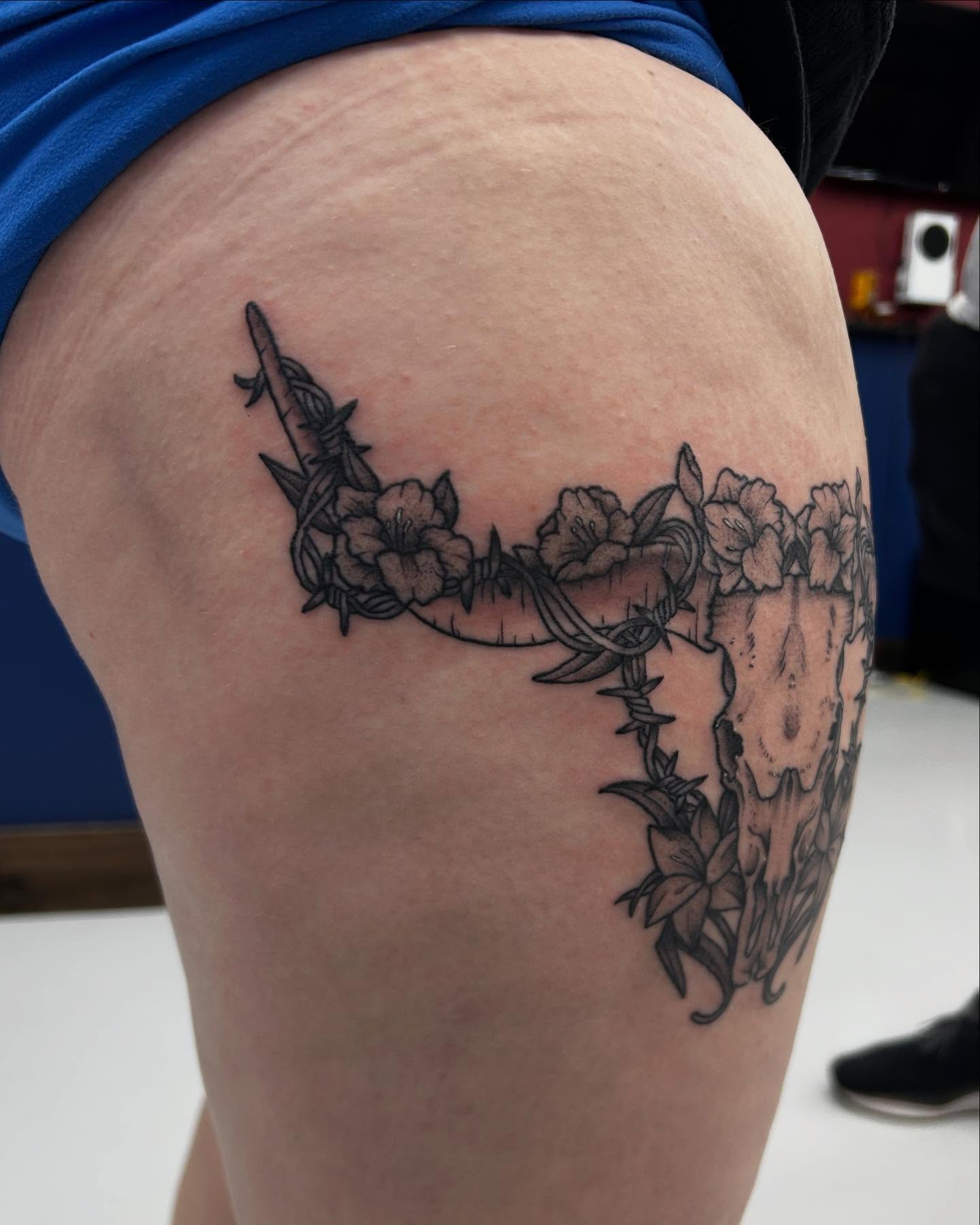 Barbed wire and flowers black and grey tattoo on the thigh by Abby Watts, Columbus, Ohio