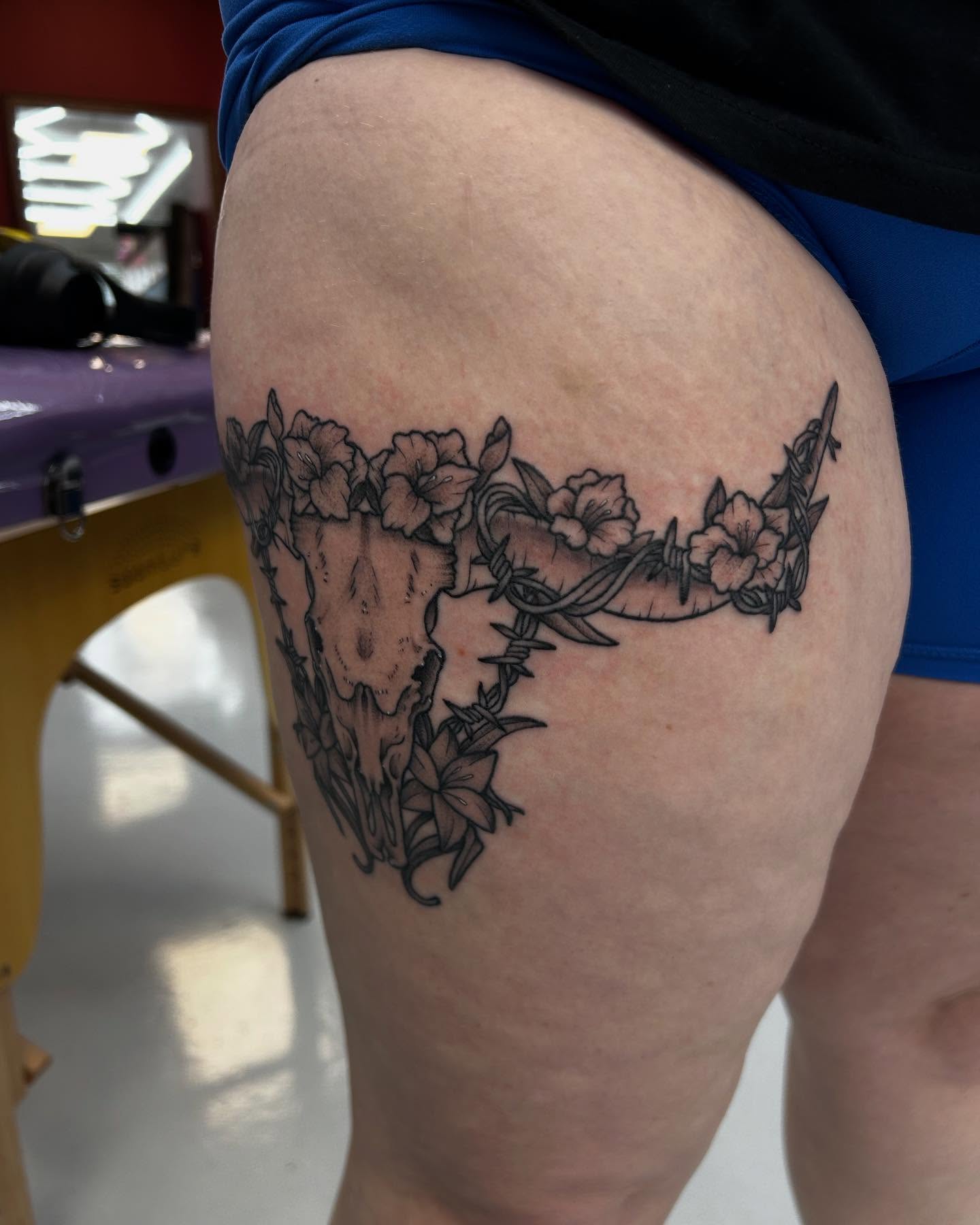 Skull and flowers black and grey tattoo on the thigh by Abby Watts, Columbus, Ohio