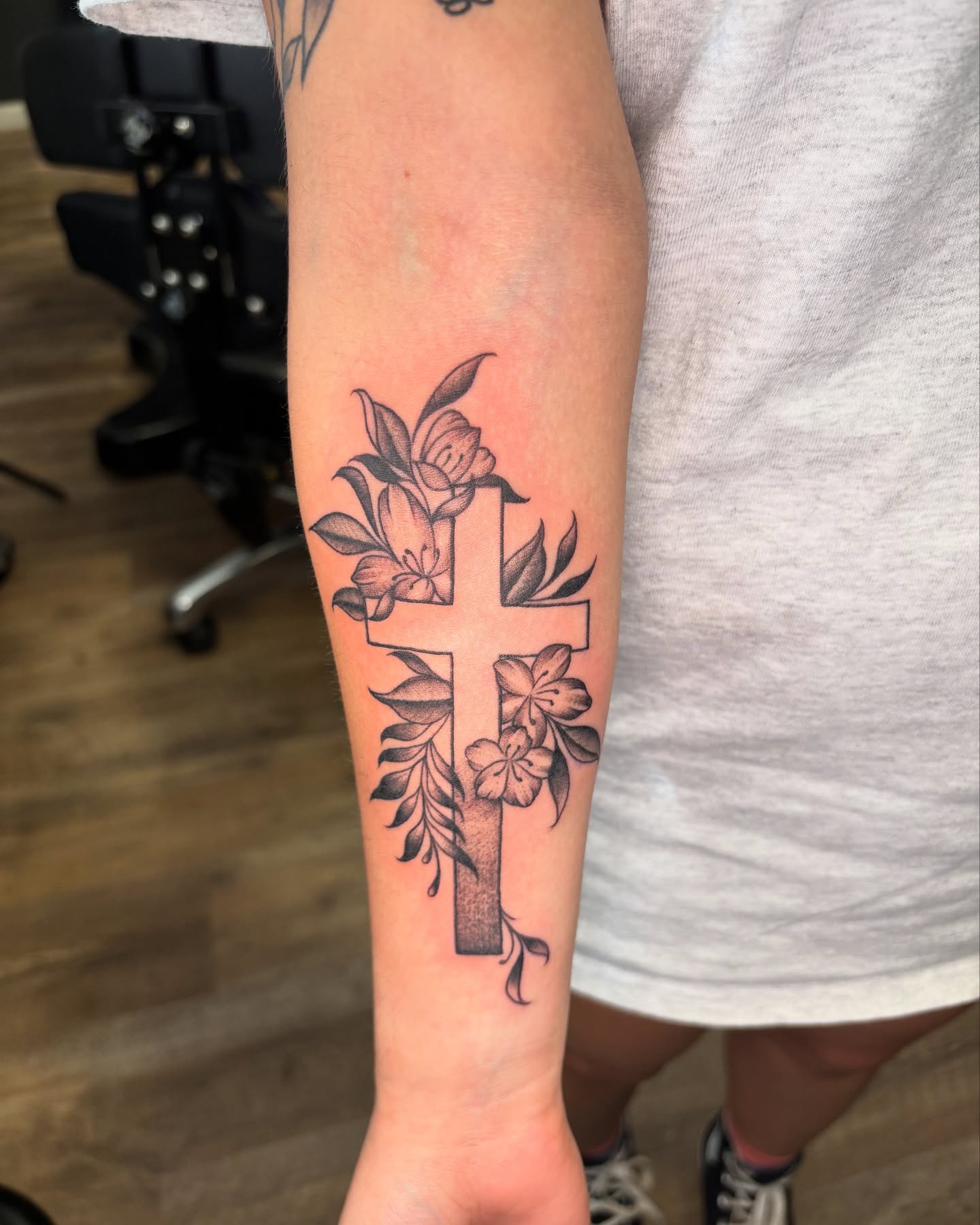 Cross with flowers black and grey tattoo on the forearm by Eric Garcia