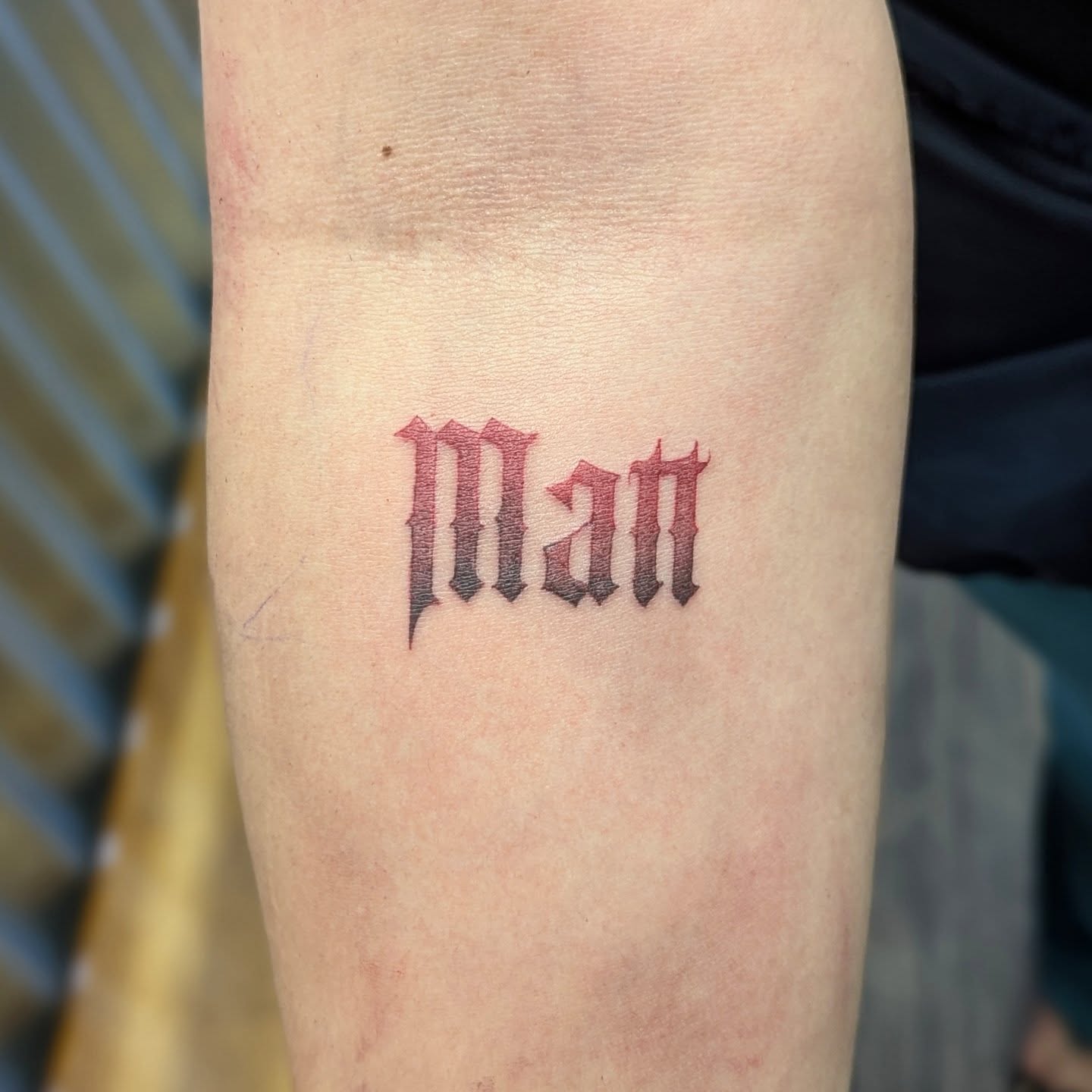 Man lettering script tattoo on the forearm by DONEL 📍Denver