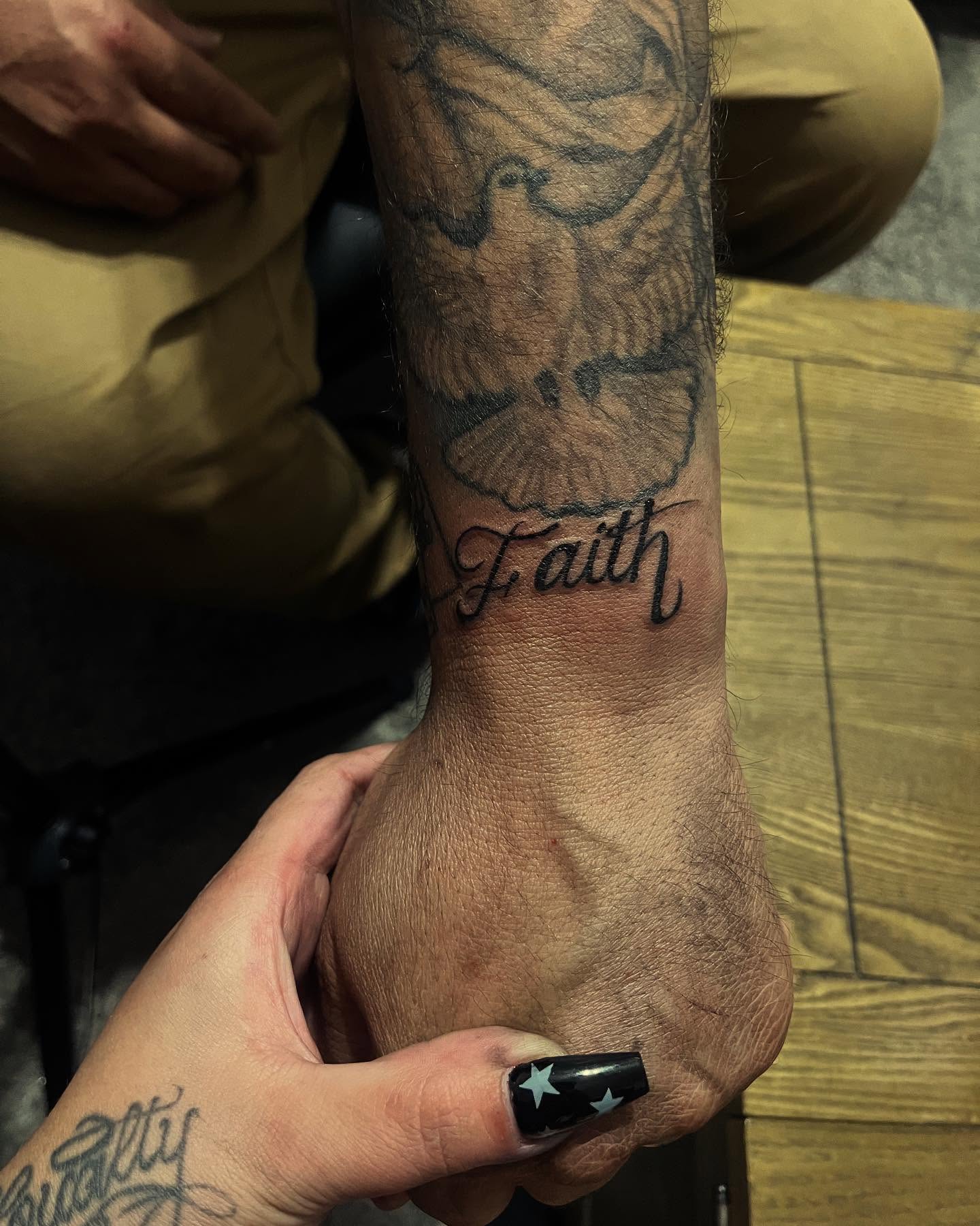 Bird and script black and grey tattoo on the forearm by Anna DeLuna