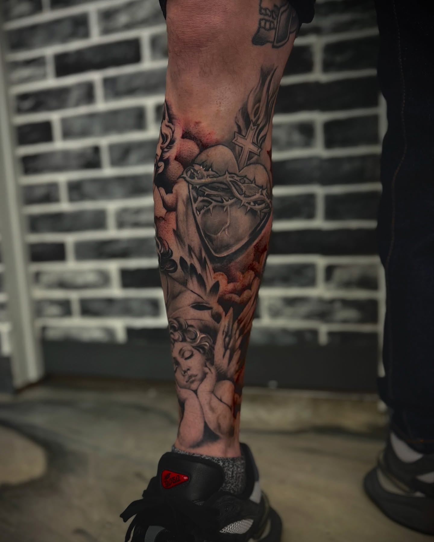 Heart with cherub realism tattoo on the calf by Mitsuko Ching