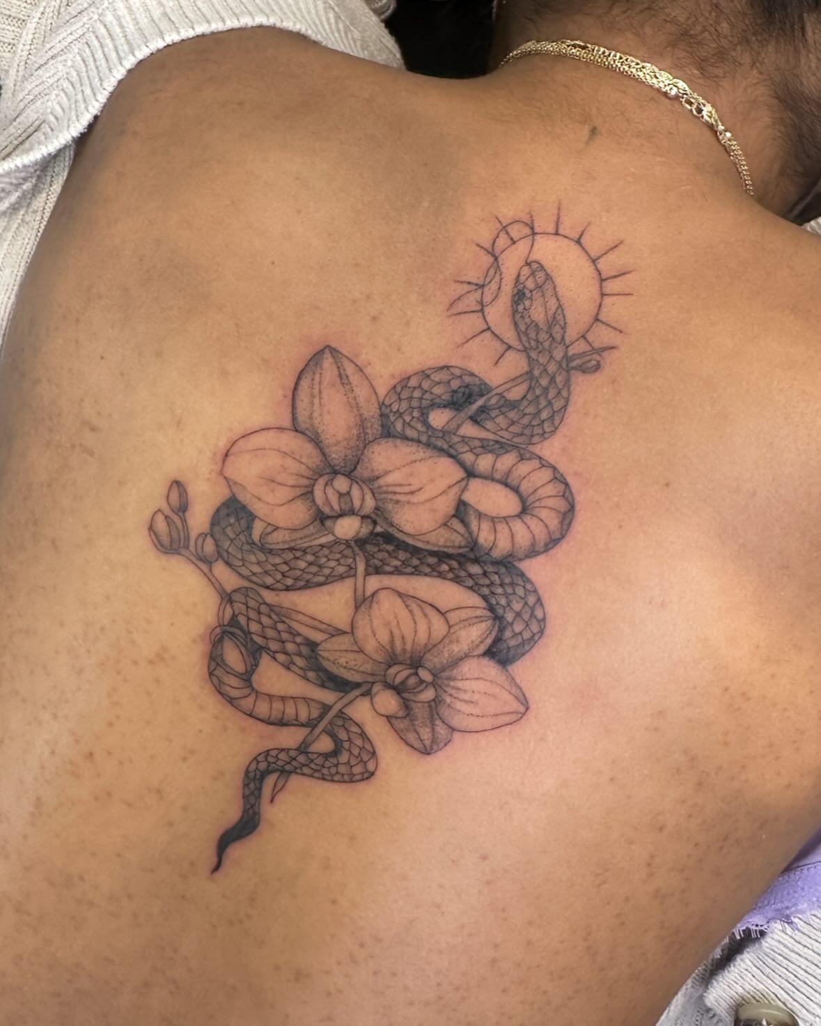 Snake and orchid realism tattoo on the back by Bell