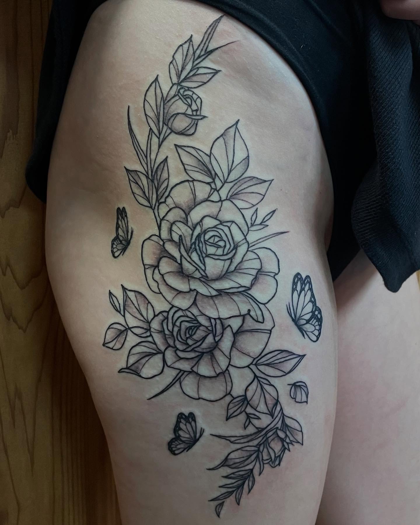 Roses and butterflies black and grey tattoo on the thigh by Anna sabrowsky