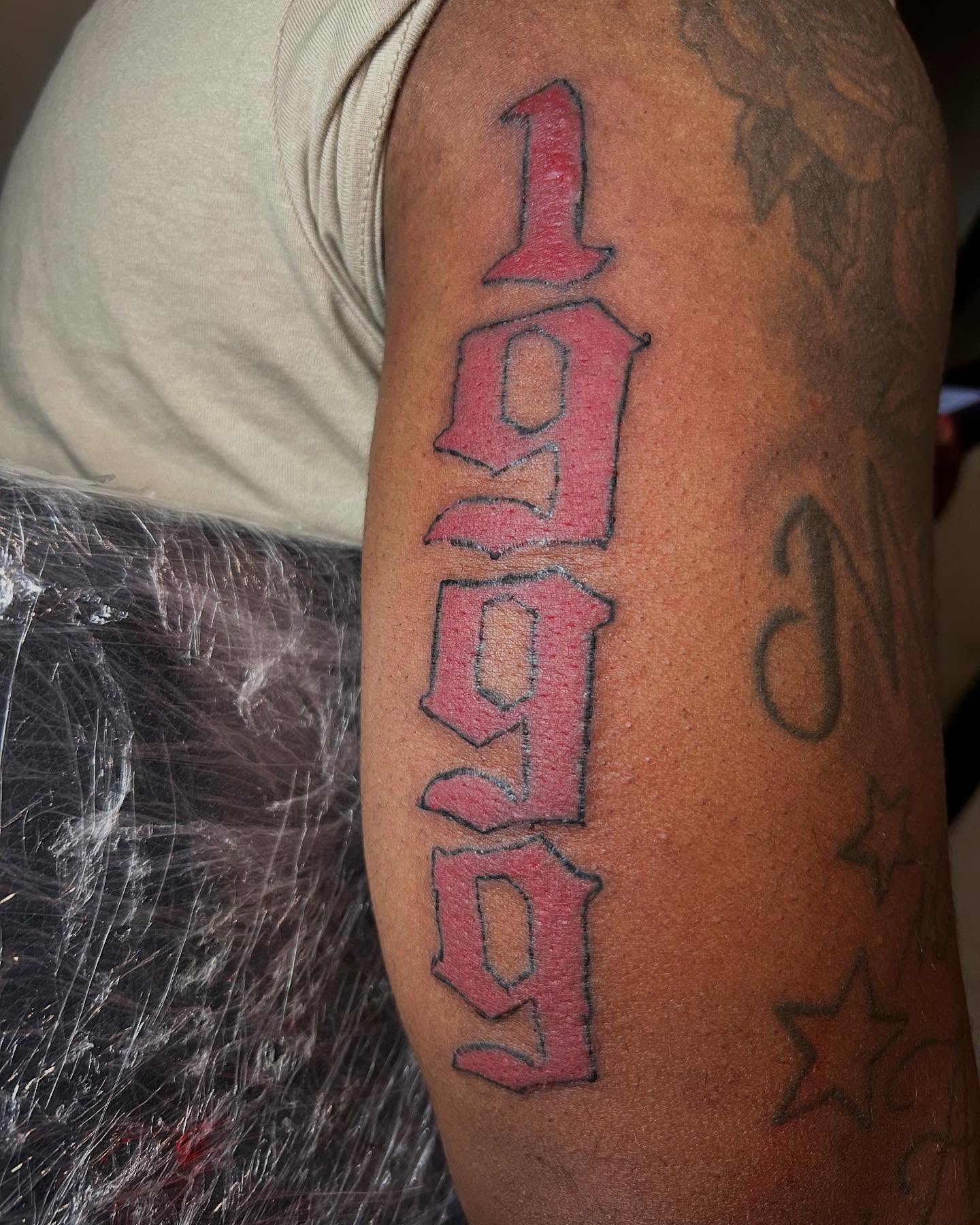 1999 lettering script tattoo on the forearm by Airika Edwards