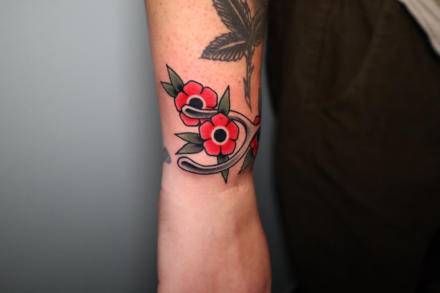 Flowers and snake American traditional tattoo on the forearm by Lauren Howard Tattoos