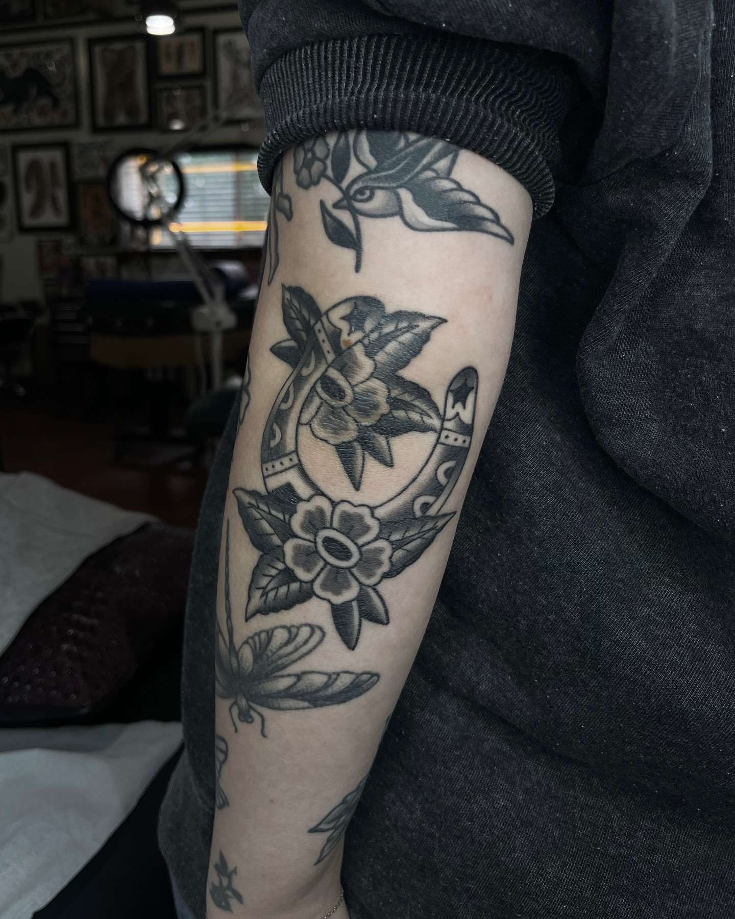 Horseshoe and flowers American traditional tattoo on the forearm by Taylor Newton