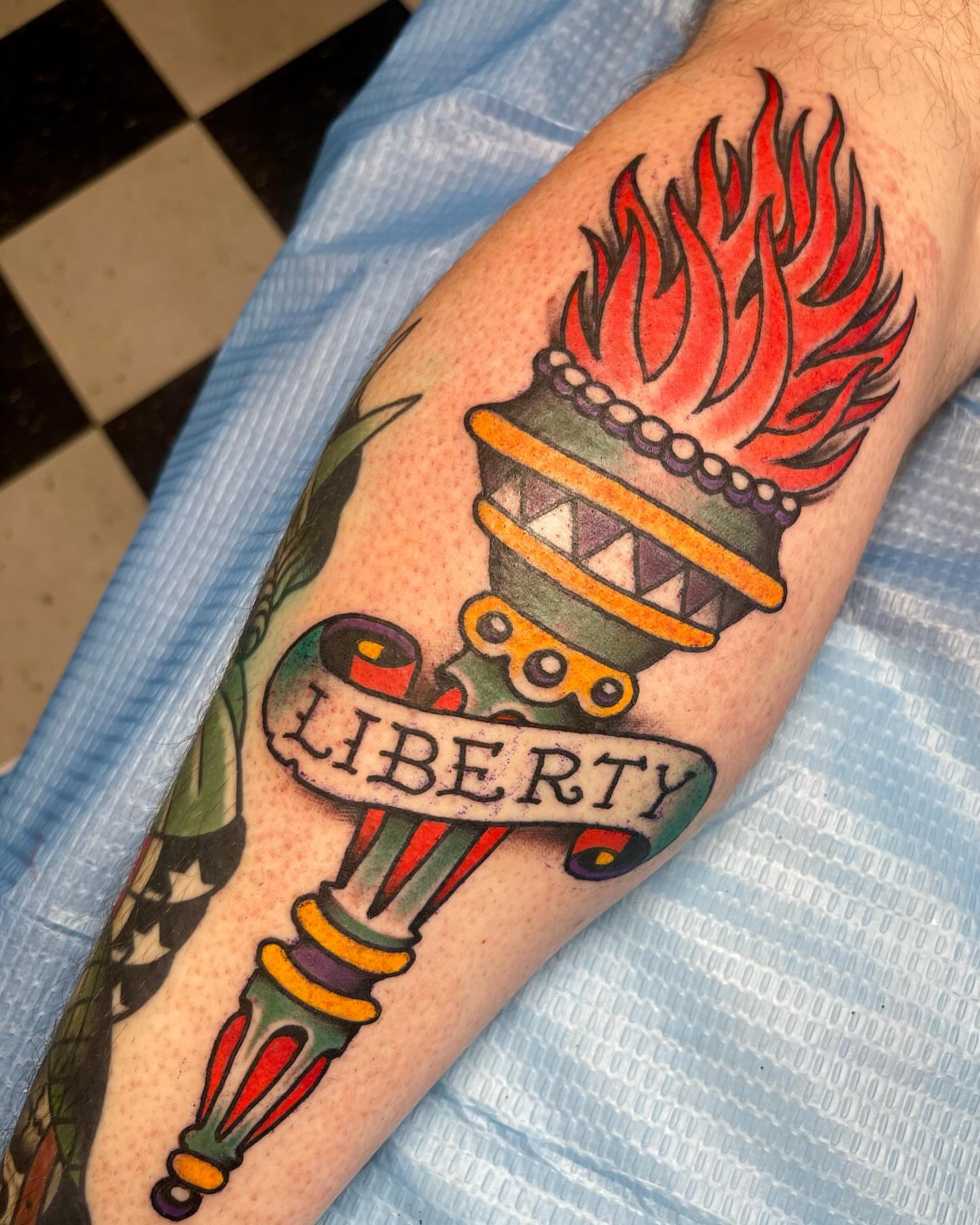 Flame-topped crown American traditional tattoo on the forearm by Mike Wilson