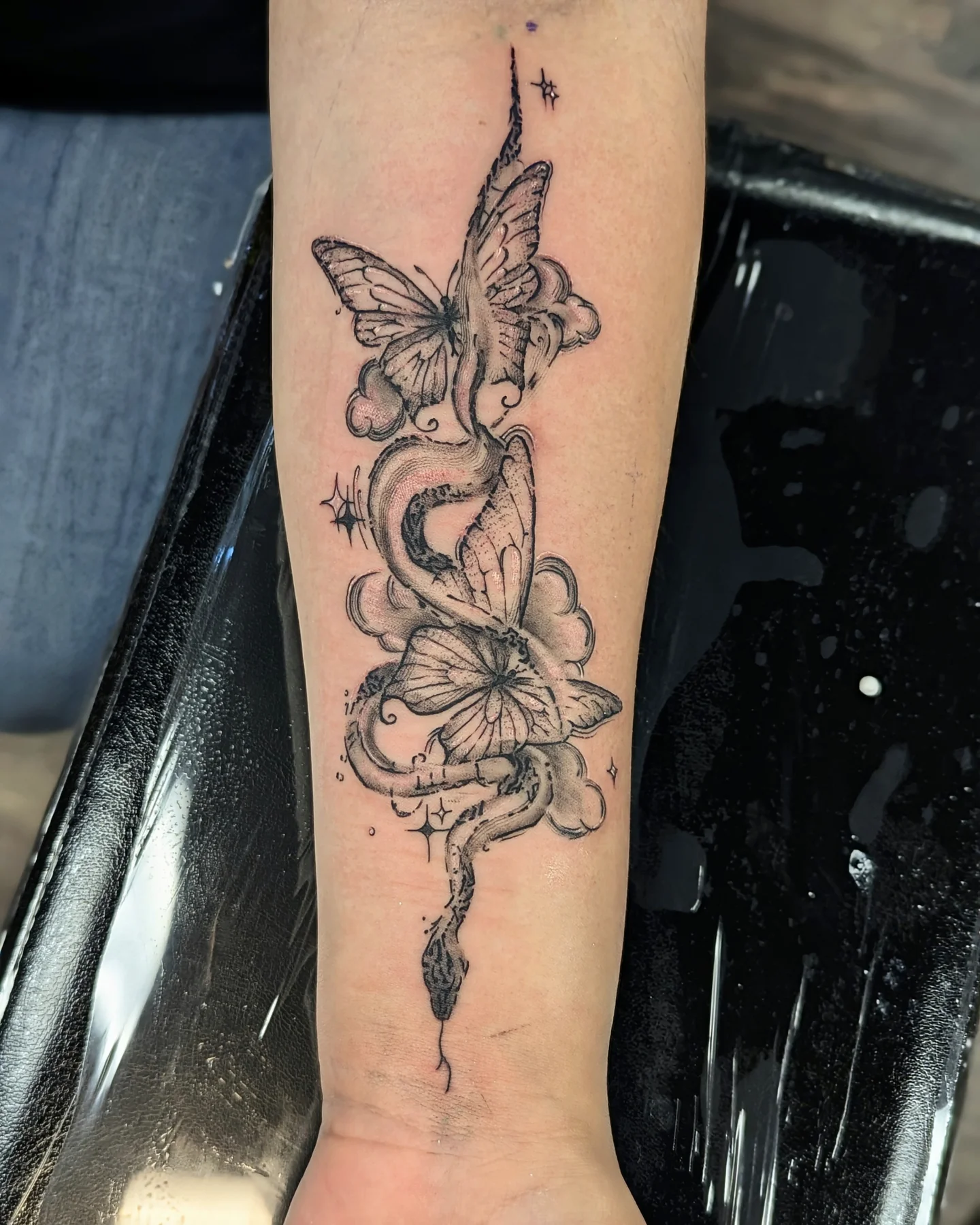 Snake and butterfly geometric tattoo on the forearm by DONEL 📍Denver