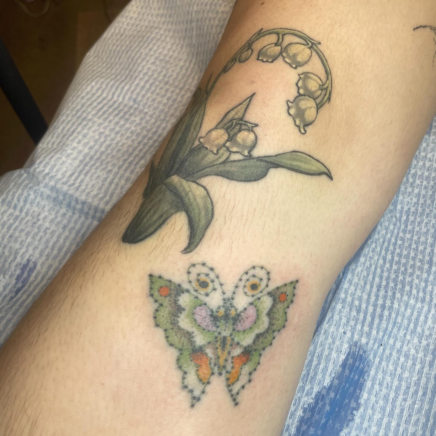 Lily of the valley and butterfly realism tattoo on the forearm by 𓉸ྀི lola hoax tattoos𓉸ྀི