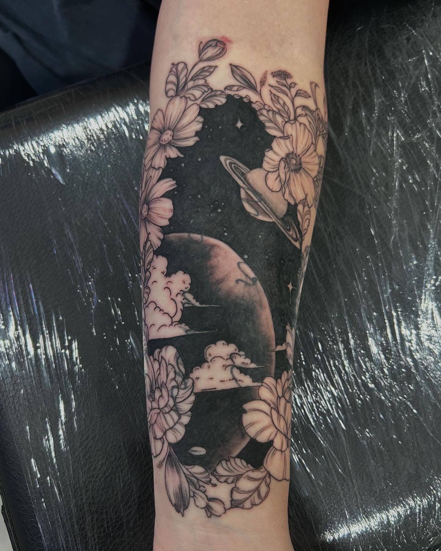 Space and flowers realism tattoo on the forearm by Jbtattoo Artistry